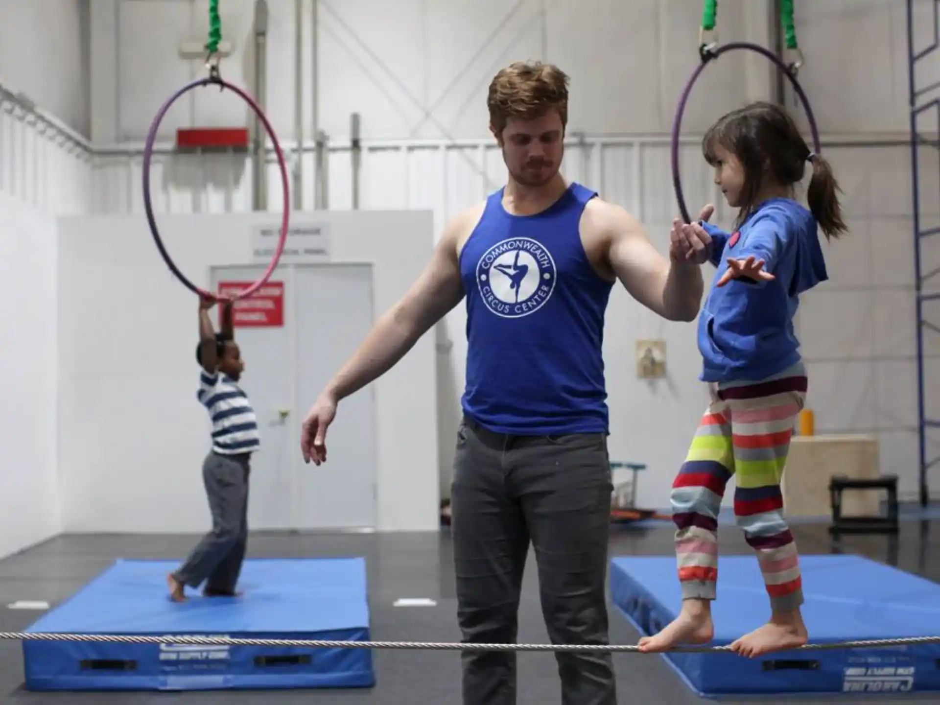a person and a couple of children playing ping pong