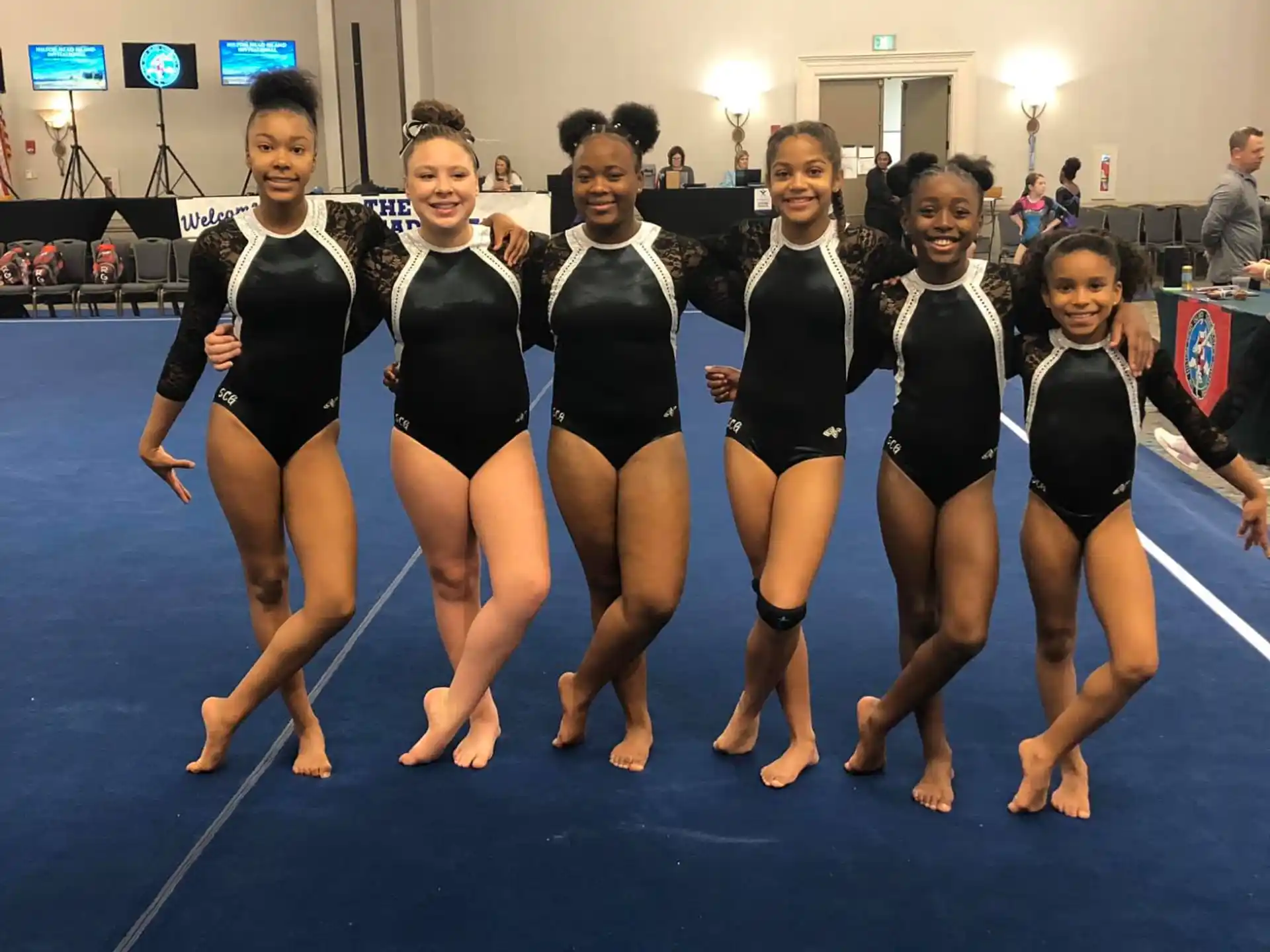 a group of women in black and white uniforms on a blue mat
