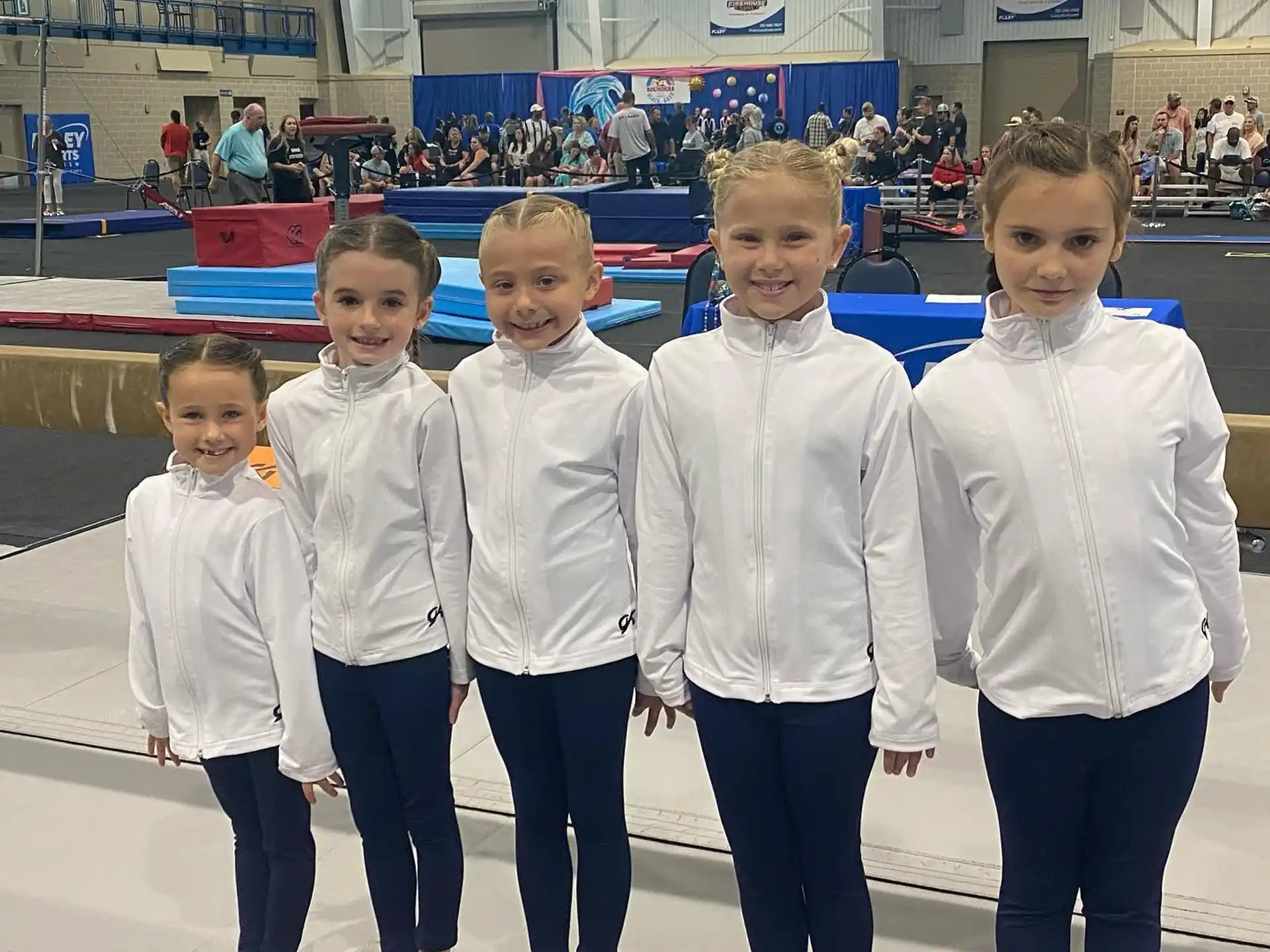 a group of children in white shirts