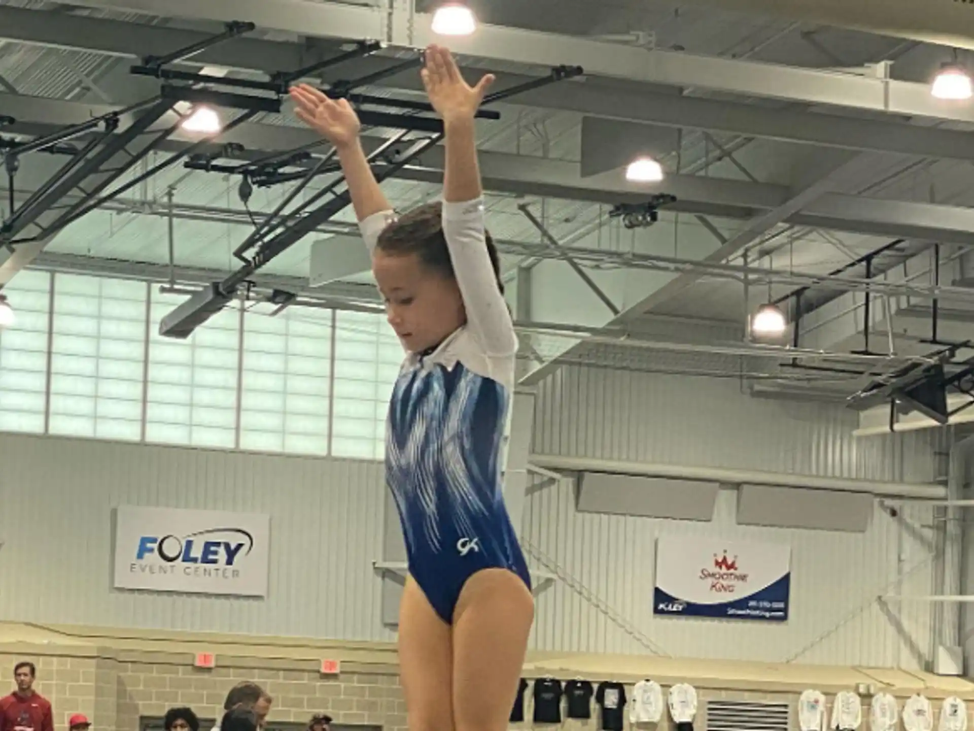 a person in a blue uniform doing a handstand in a gym