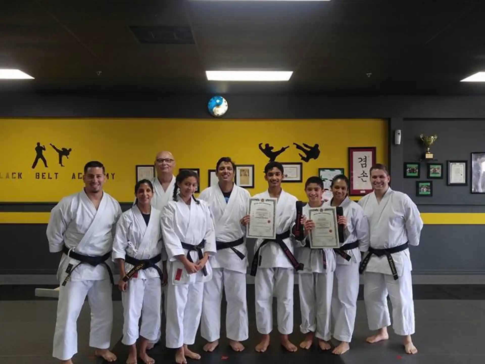 a group of people in white karate uniforms posing for a photo