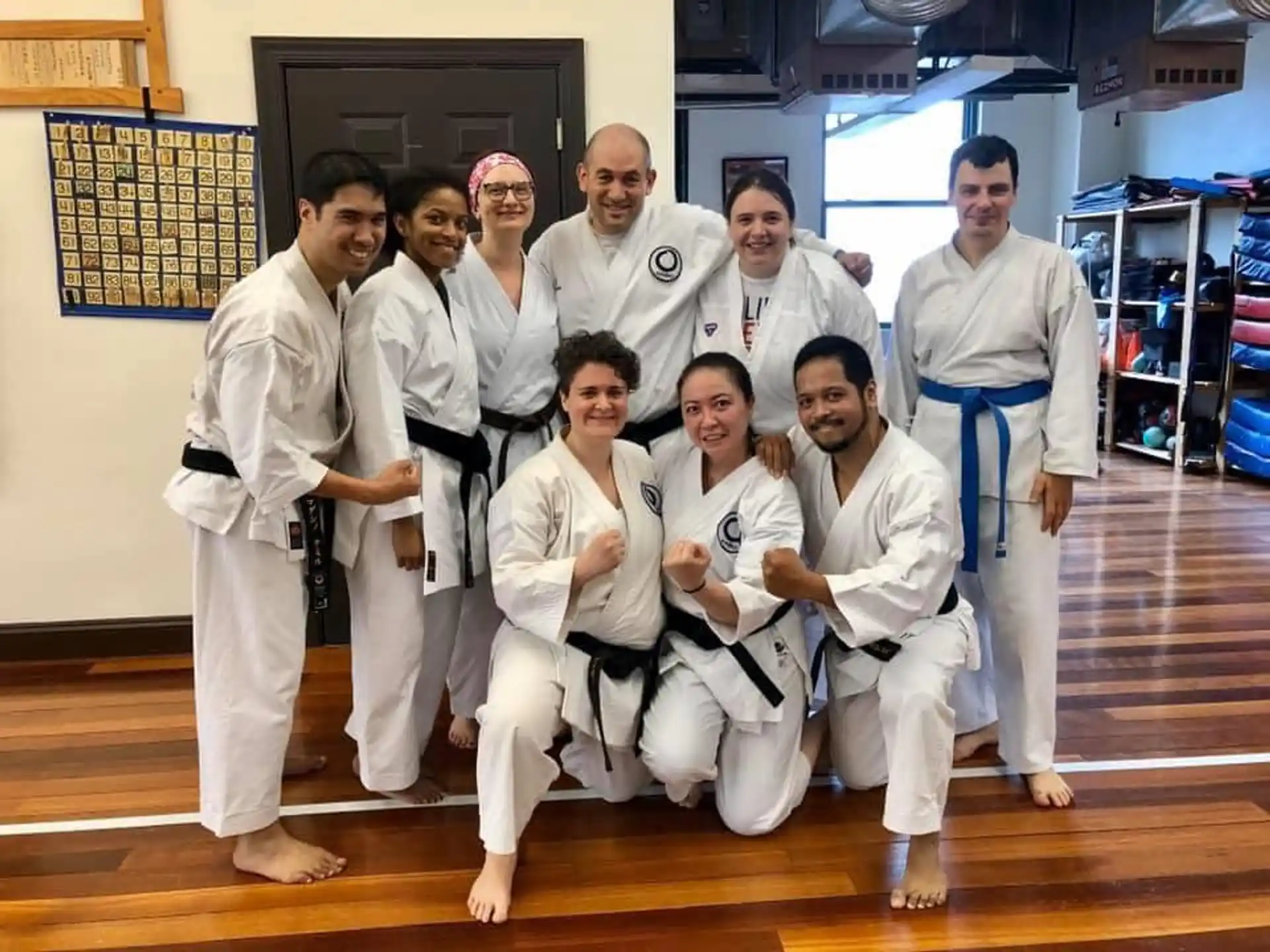 a group of people in white karate uniforms posing for a photo