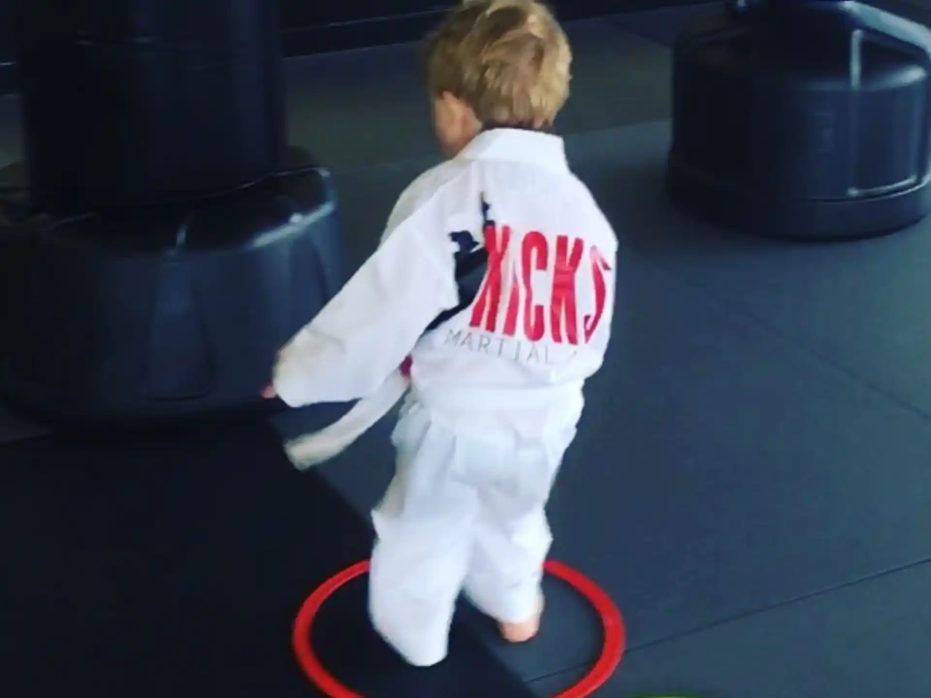 a child standing on a red and white circular object
