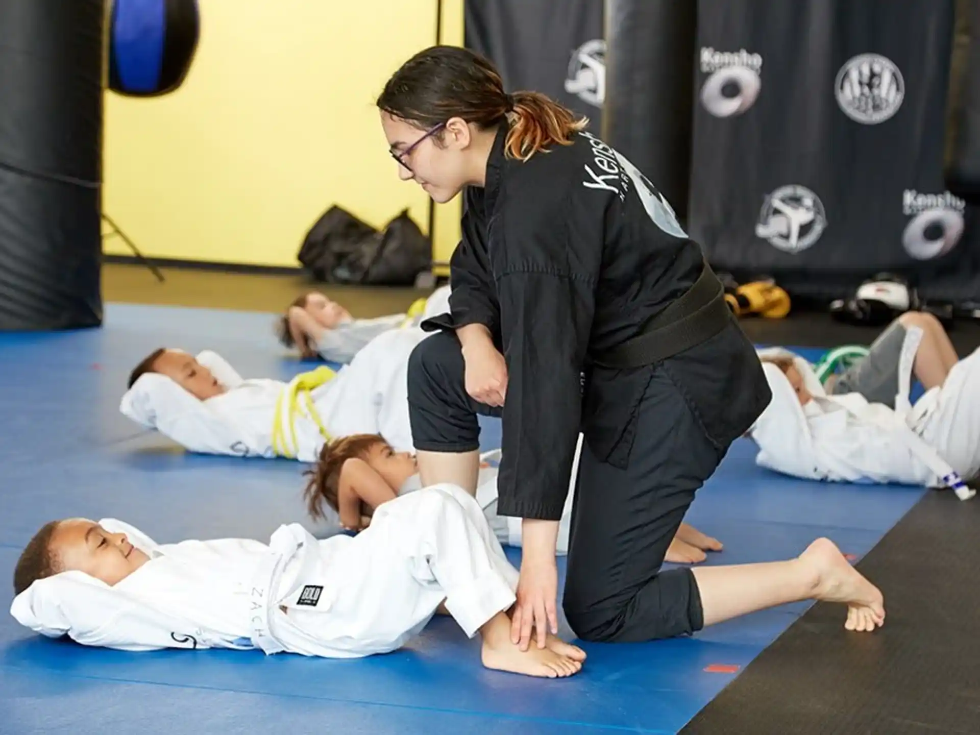 a woman doing push ups with a man lying on the ground