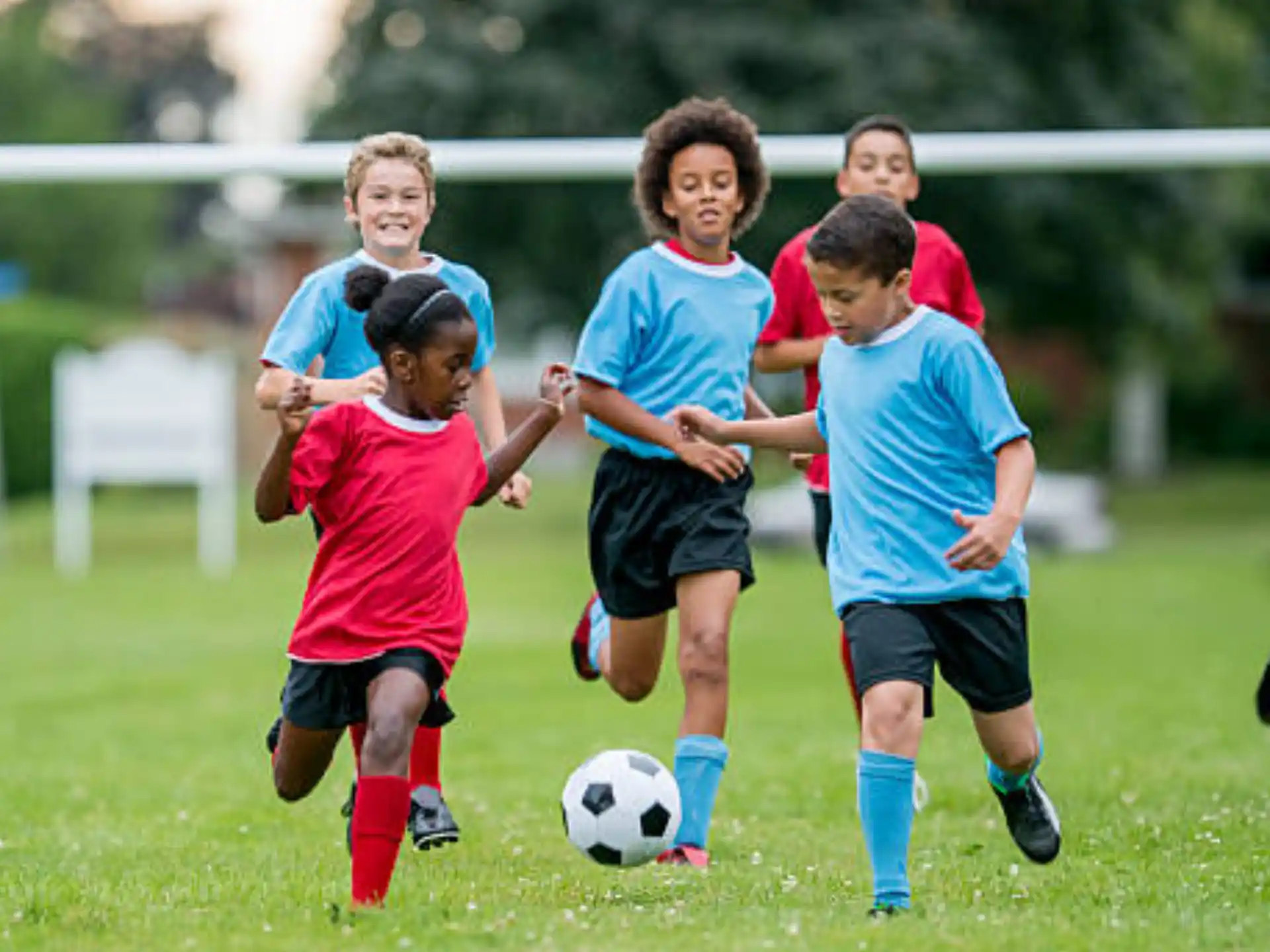 a group of kids compete over a football ball