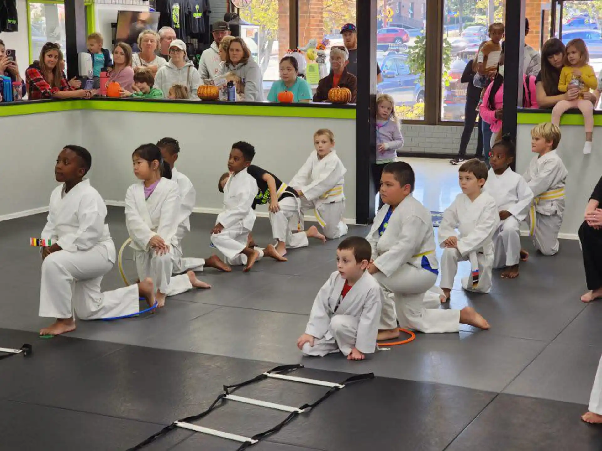 a group of people in white karate uniforms sitting on the floor