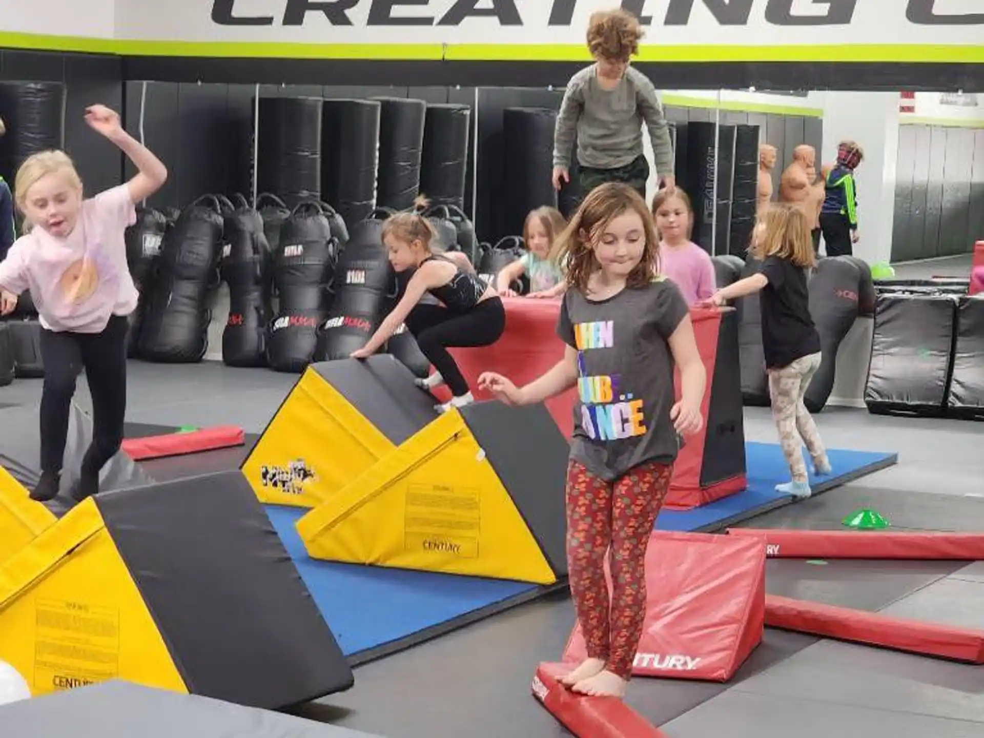 a group of people standing on a mat in front of a sign