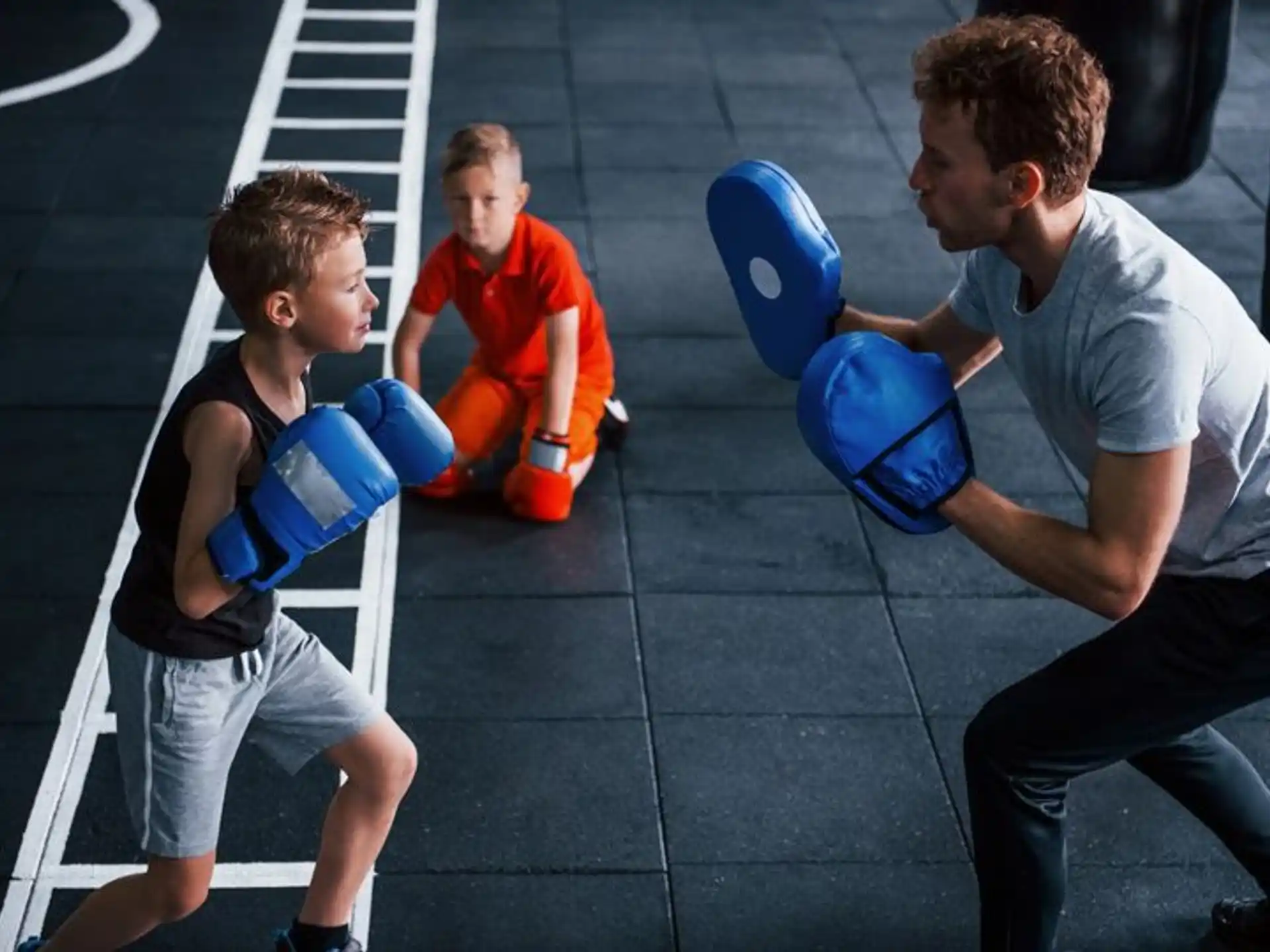 a man and a couple of boys in boxing gloves