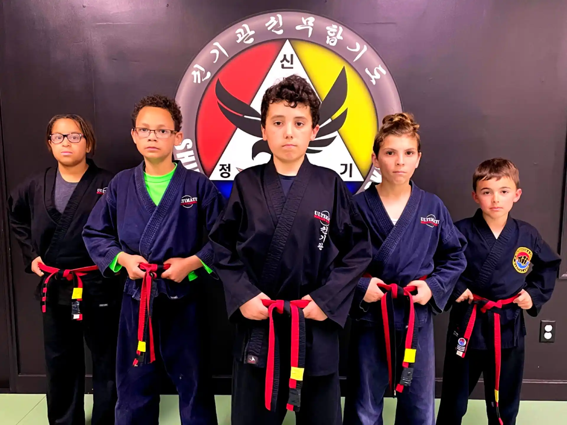 a group of boys in martial arts uniforms posing for a photo