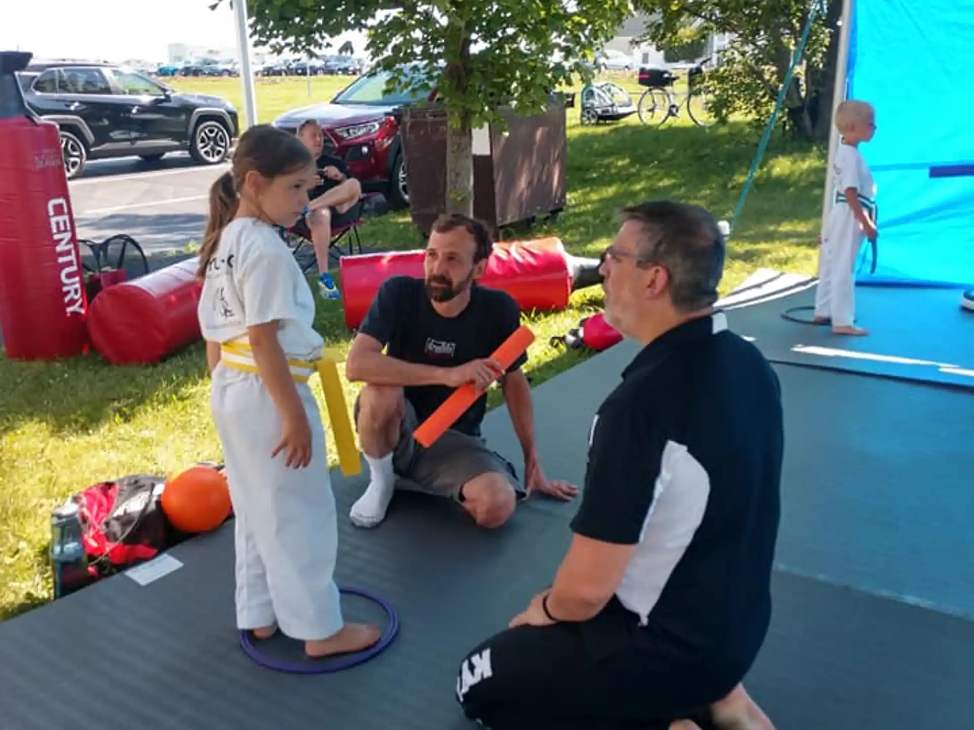 a man and a woman kneeling on the ground next to a girl