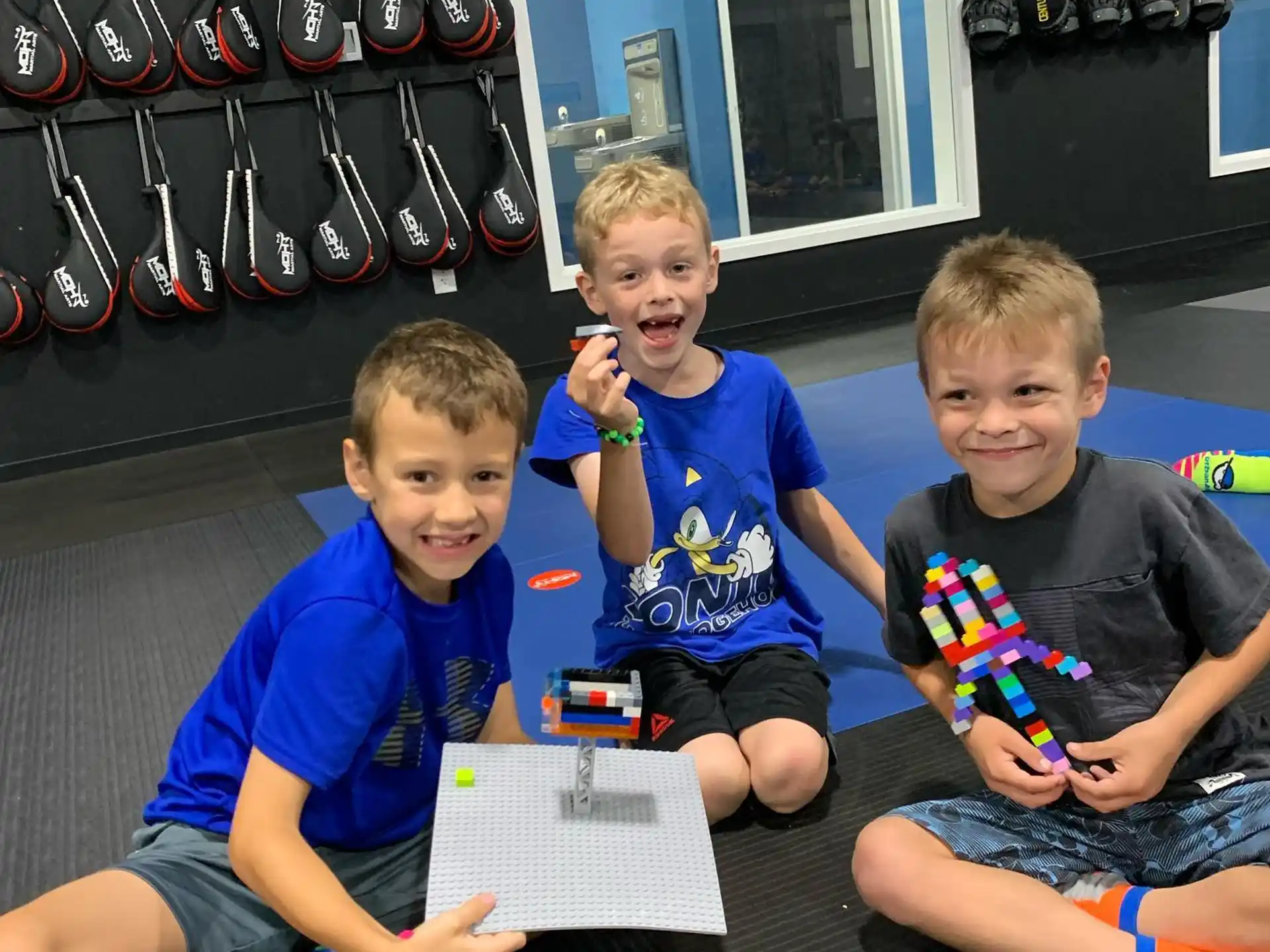 a group of boys sitting on the floor with tools and a book