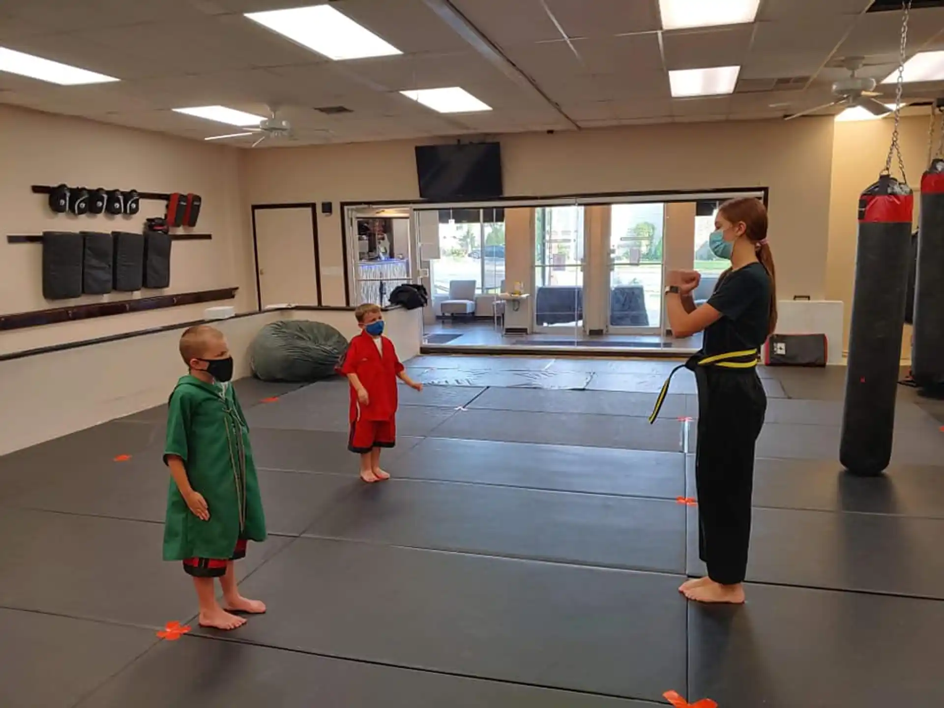 a person and a few children in a gym