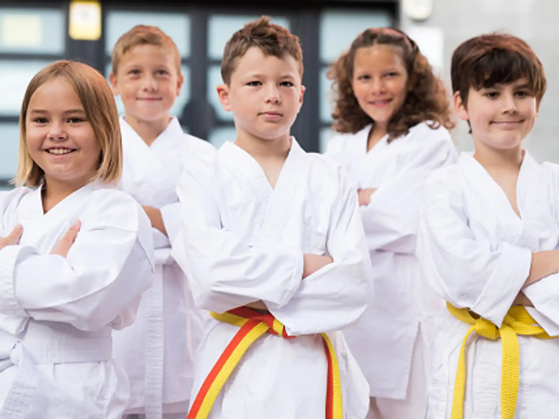 a group of children in white karate uniforms