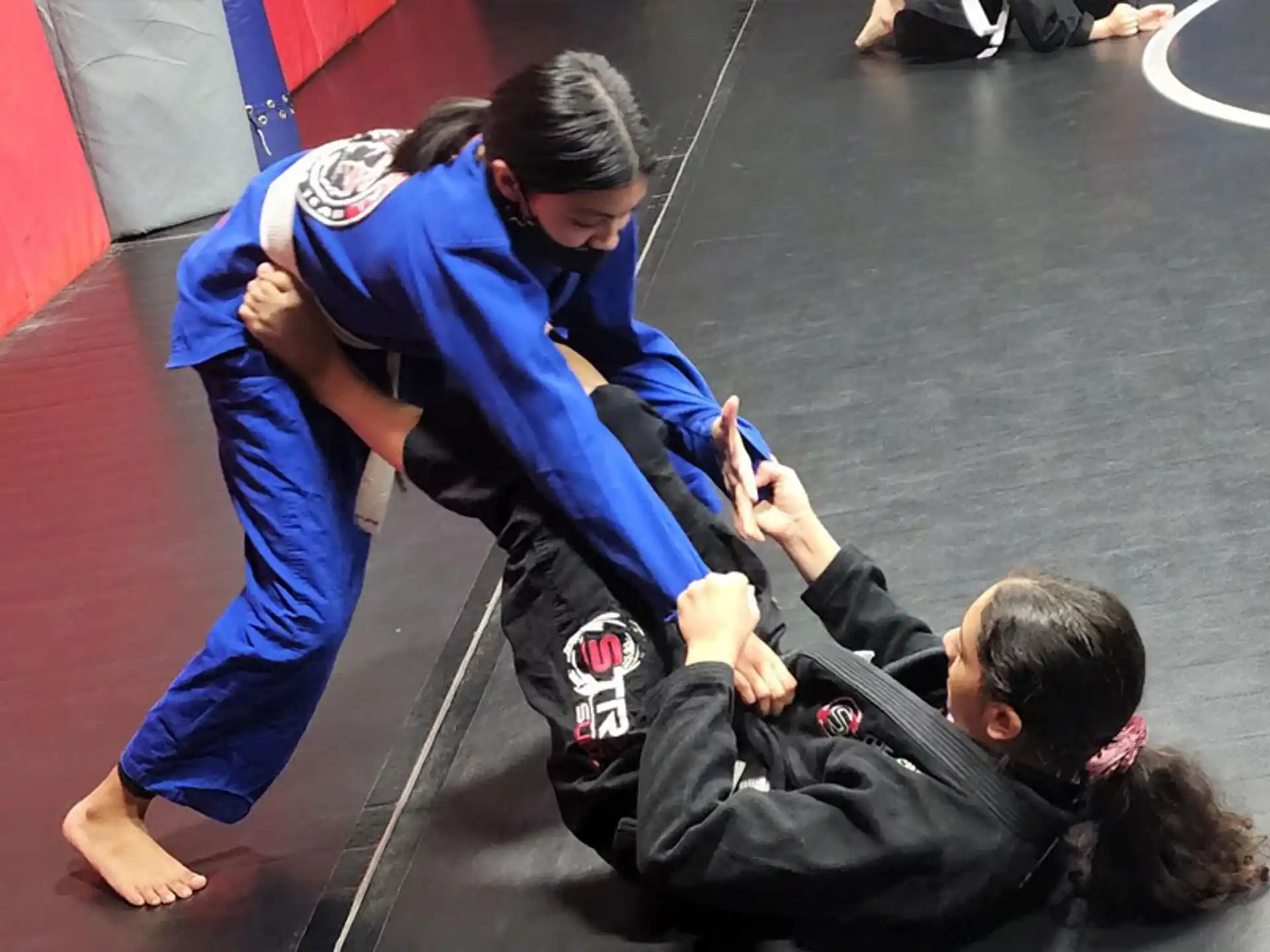 a man doing a handstand on a mat with another man