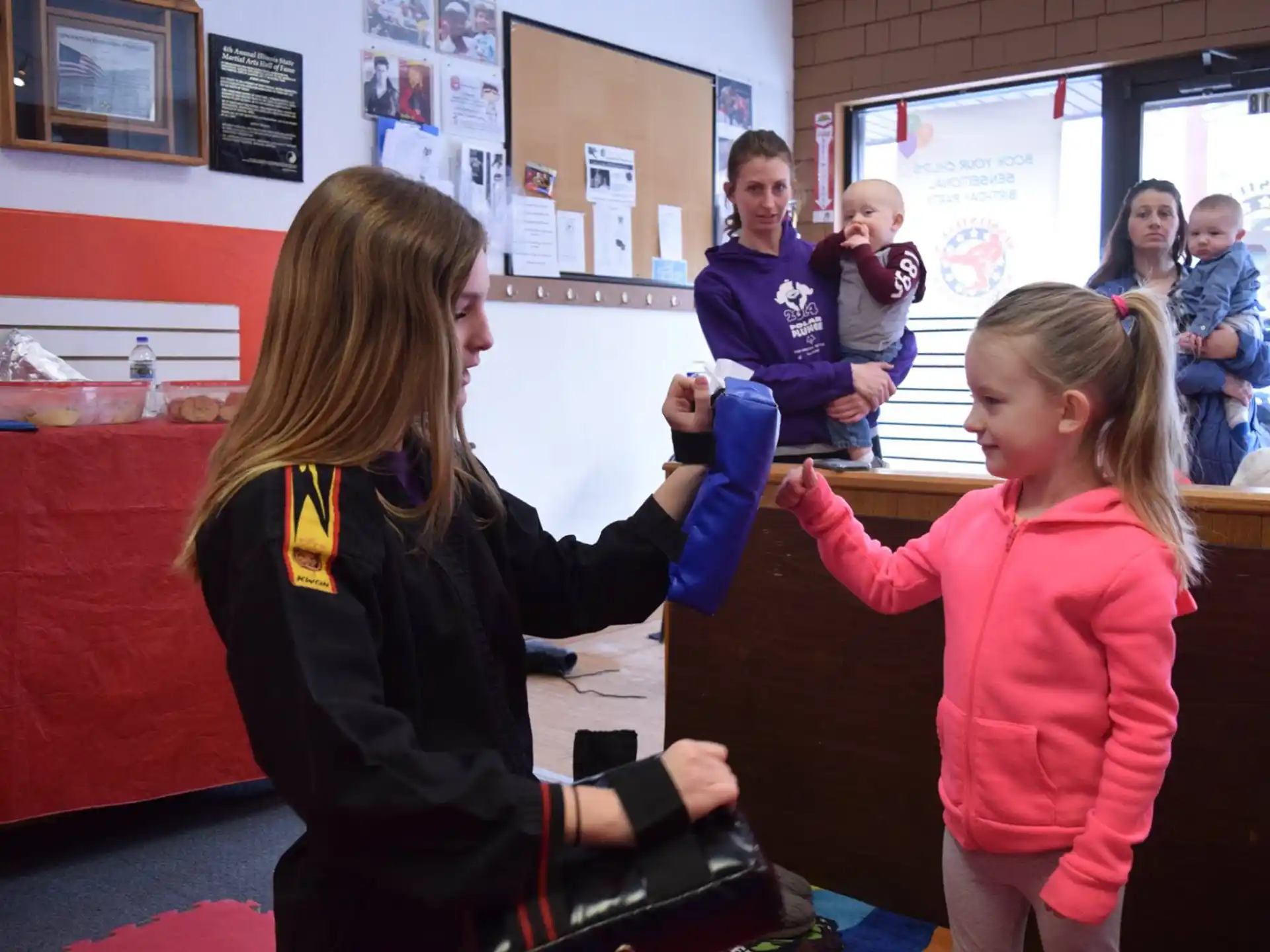 a person helping a girl with a bag