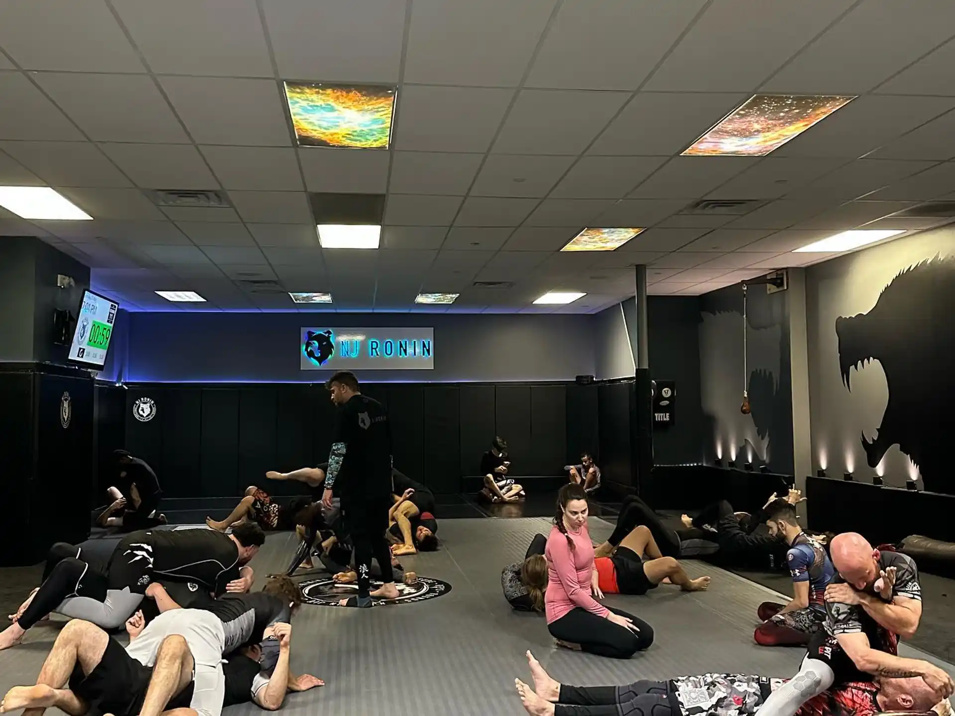 a group of people sitting on the floor in a room with a person standing in front of a
