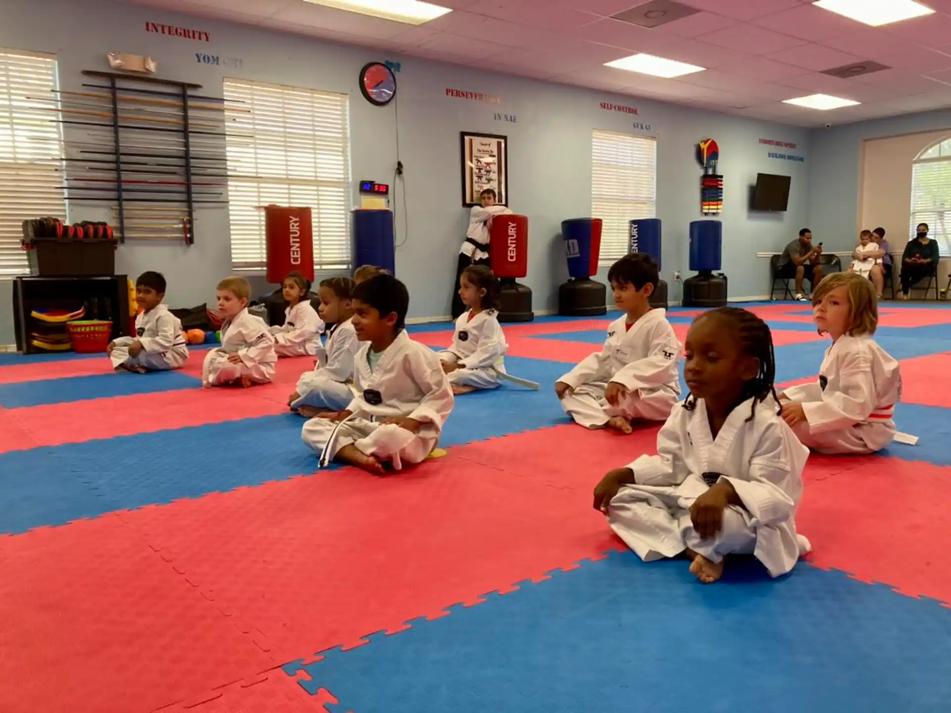 a group of children sitting on a mat in a classroom