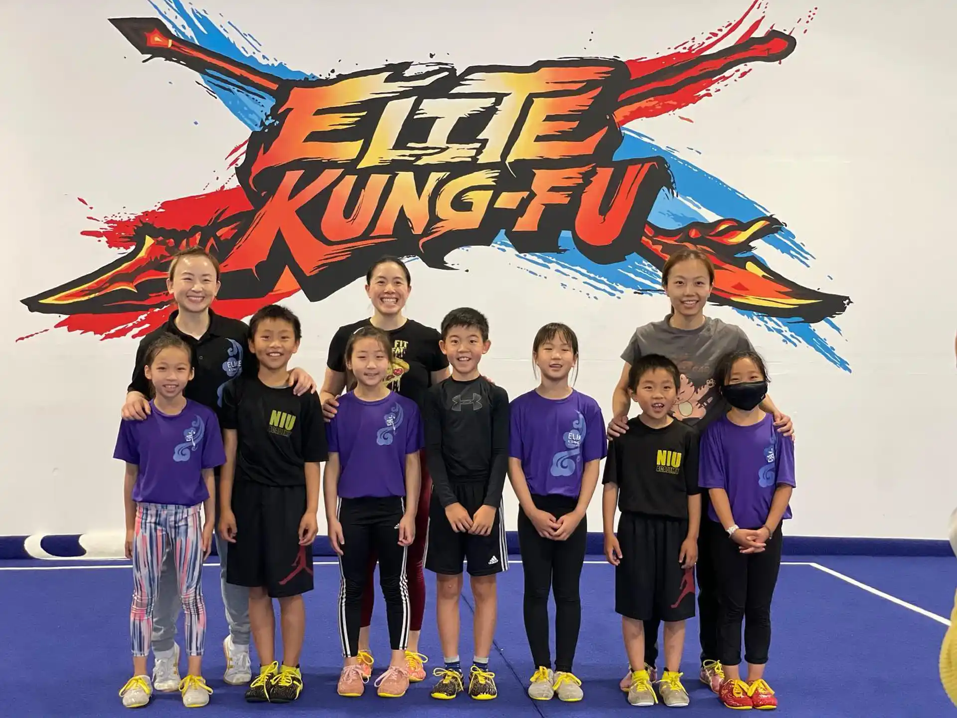 a group of kids posing for a photo in front of a banner