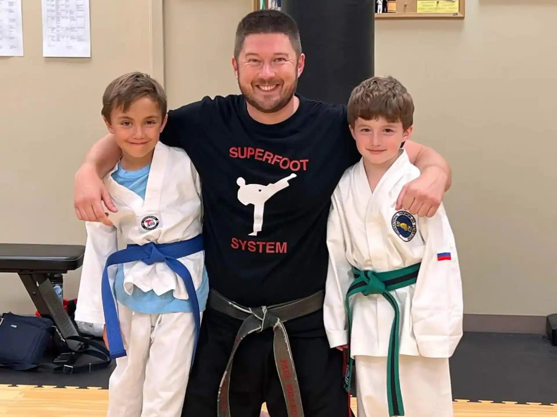 a person and two boys in karate uniforms