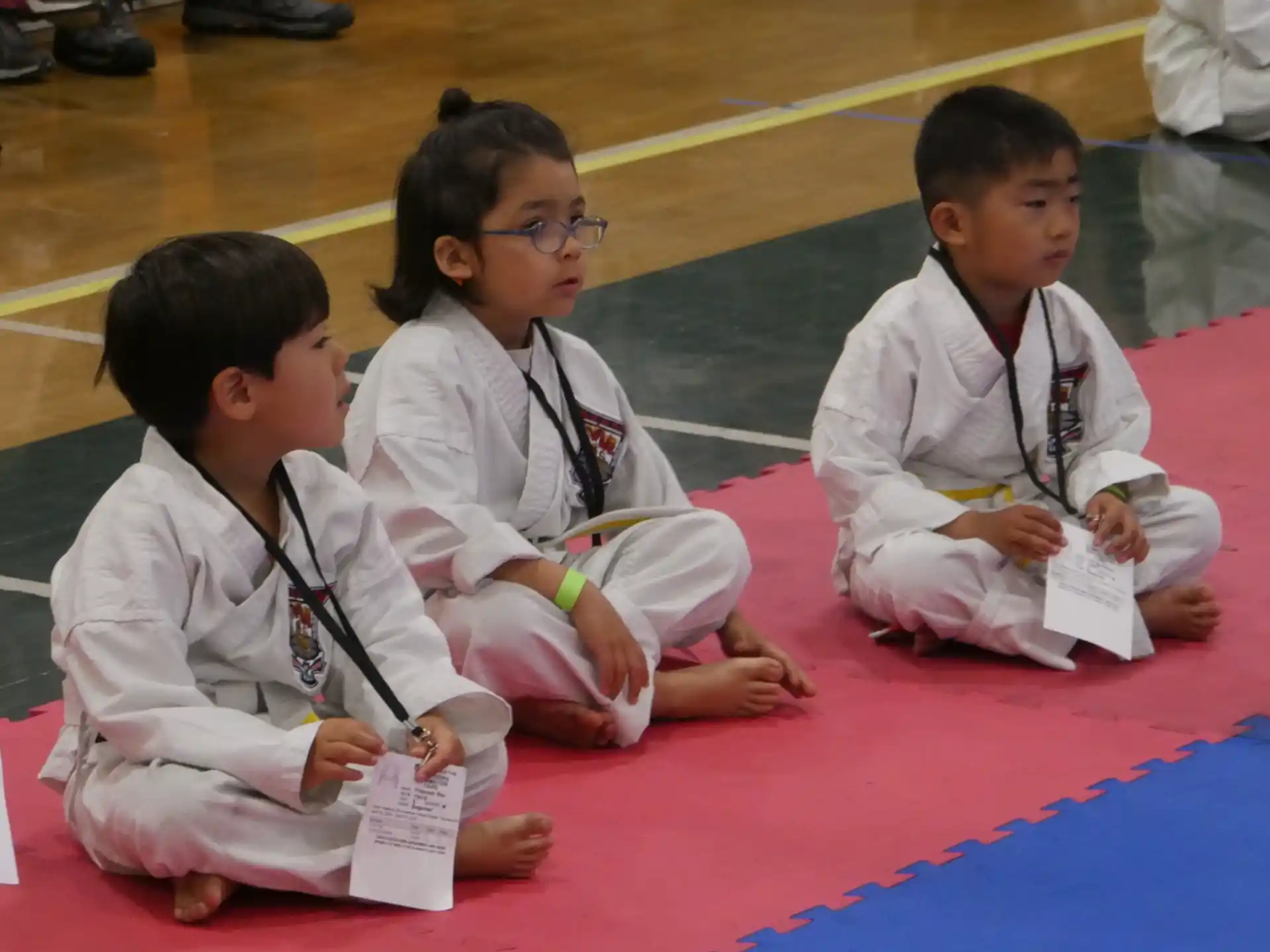a few young boys sitting on the floor reading books