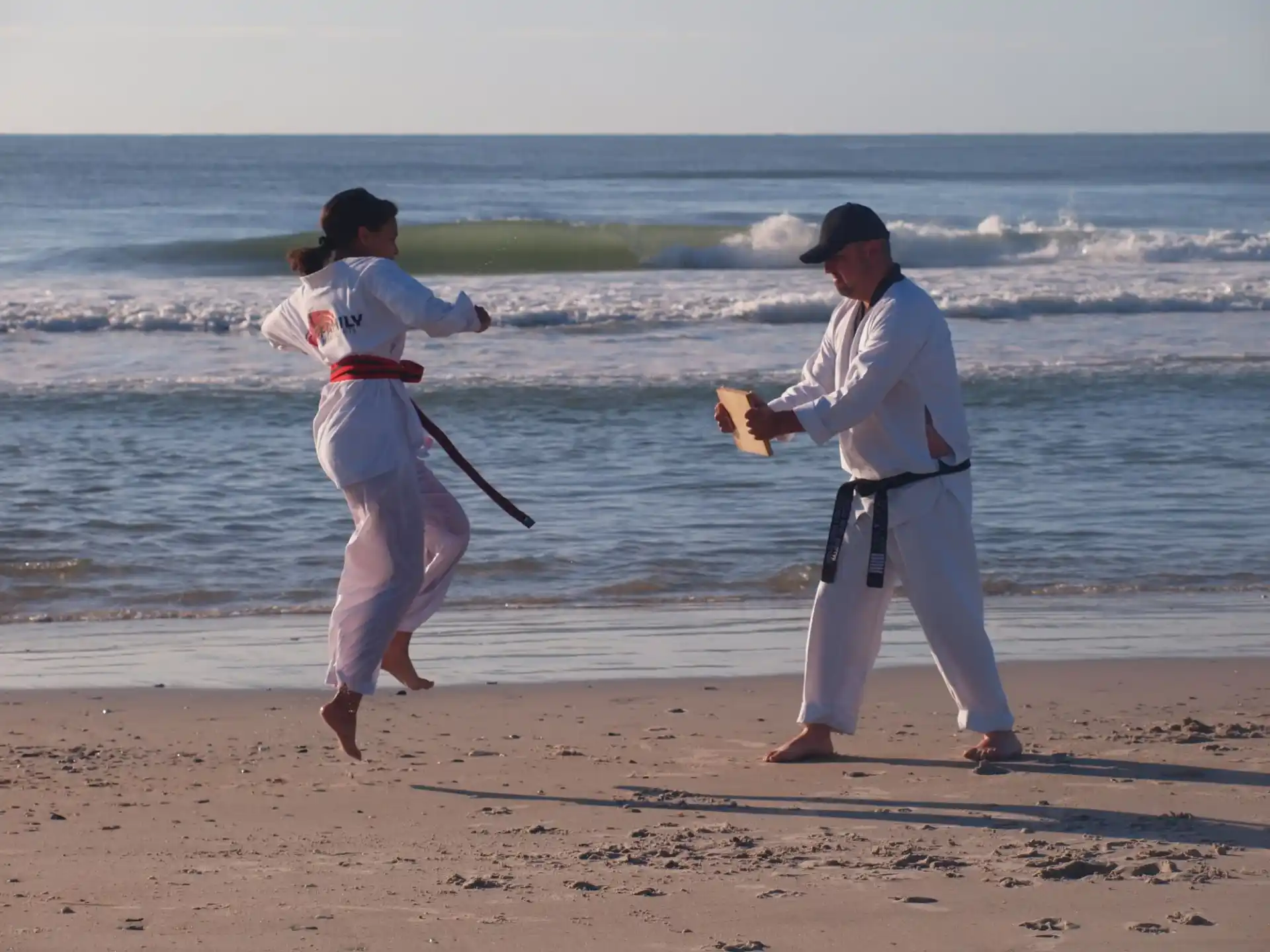 a man and a woman playing baseball on a beach