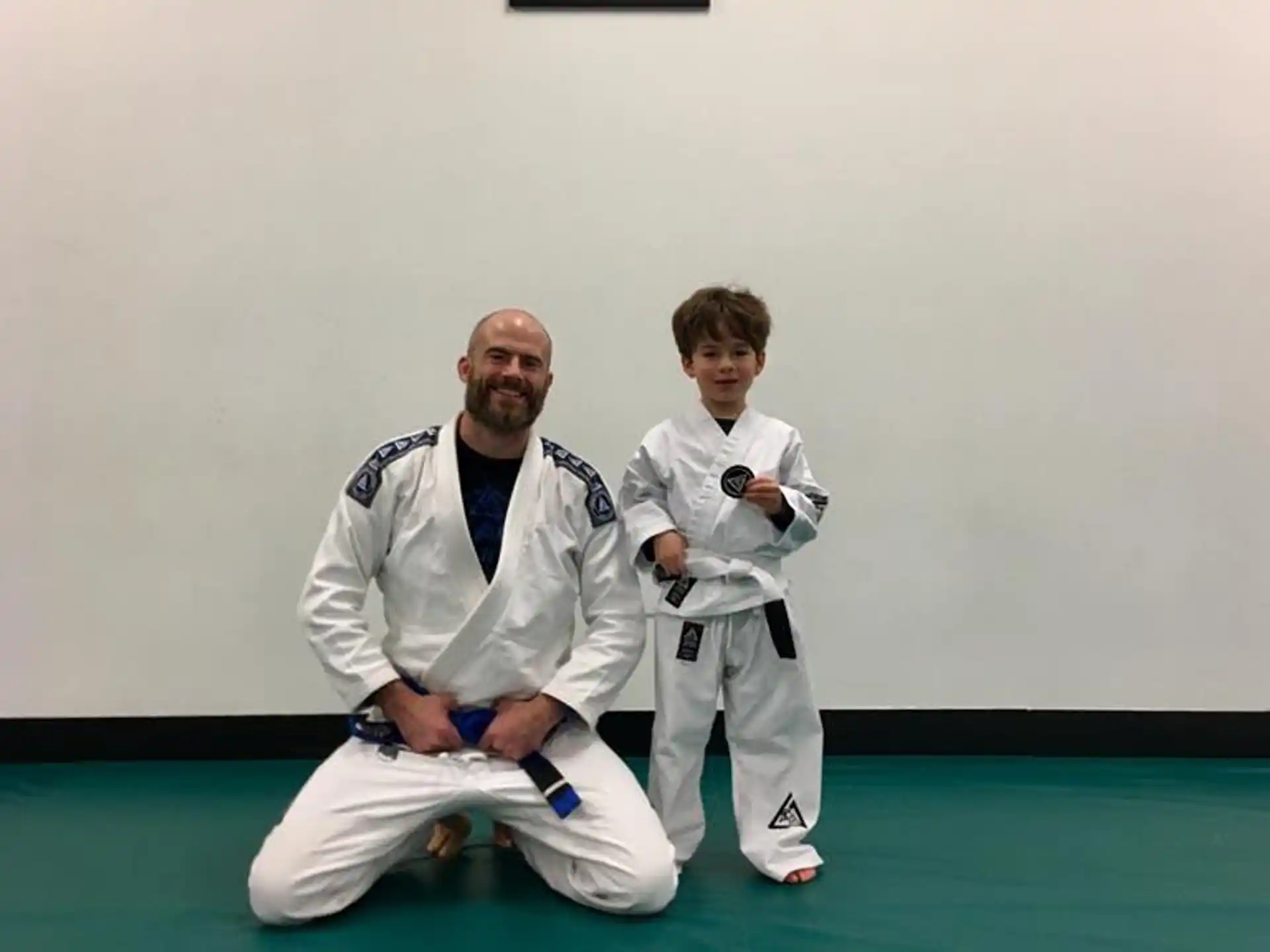 a man kneeling next to a boy