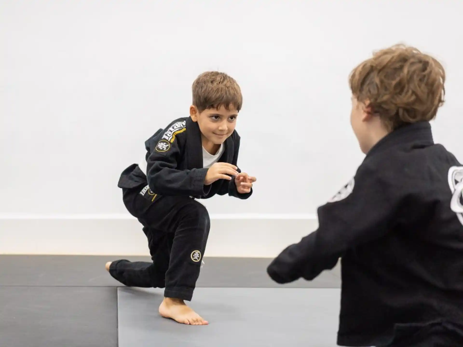 a boy kneeling next to a person in a uniform