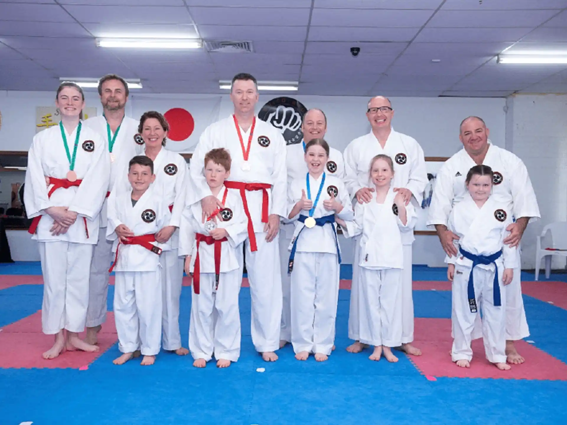 a group of people in white karate uniforms posing for a photo