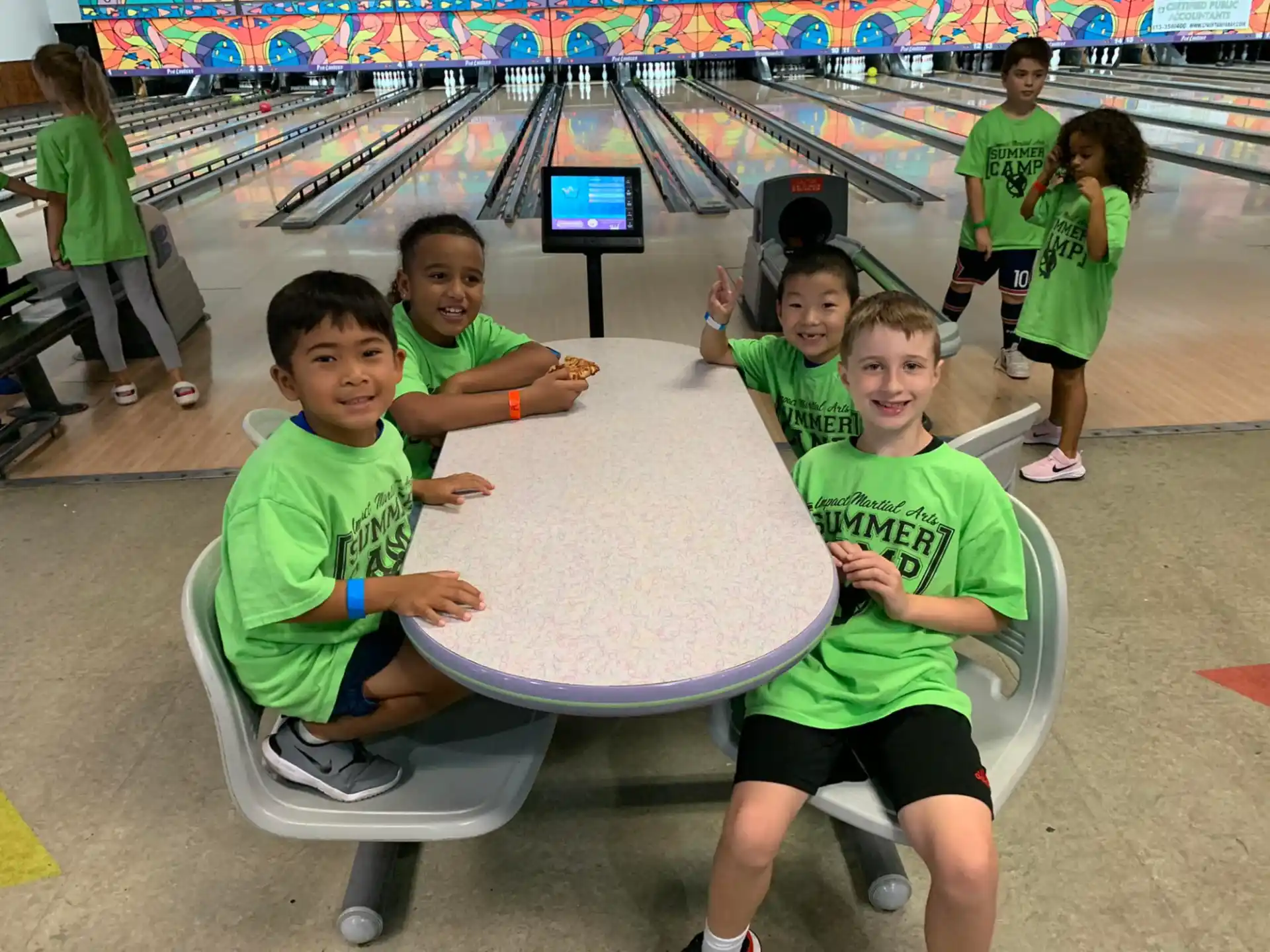 a group of children in green shirts