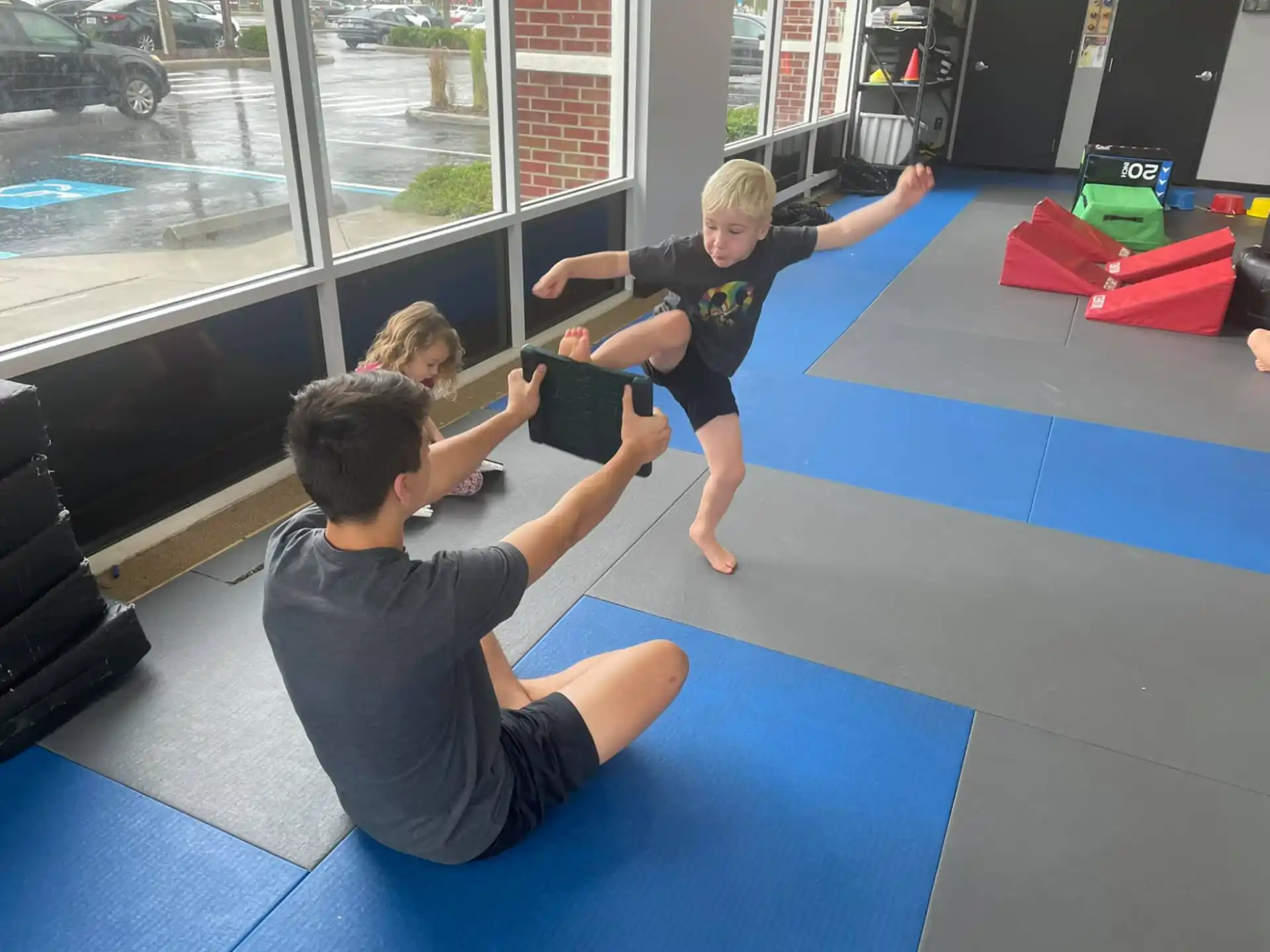 a group of children playing on a mat in a room with a window