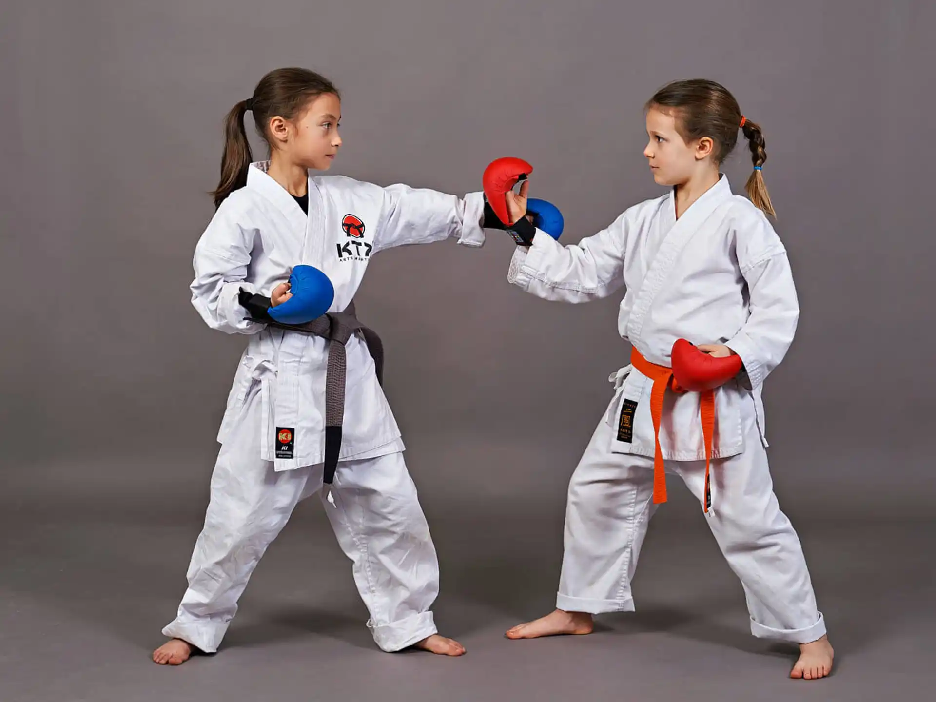 a couple of girls in karate uniforms