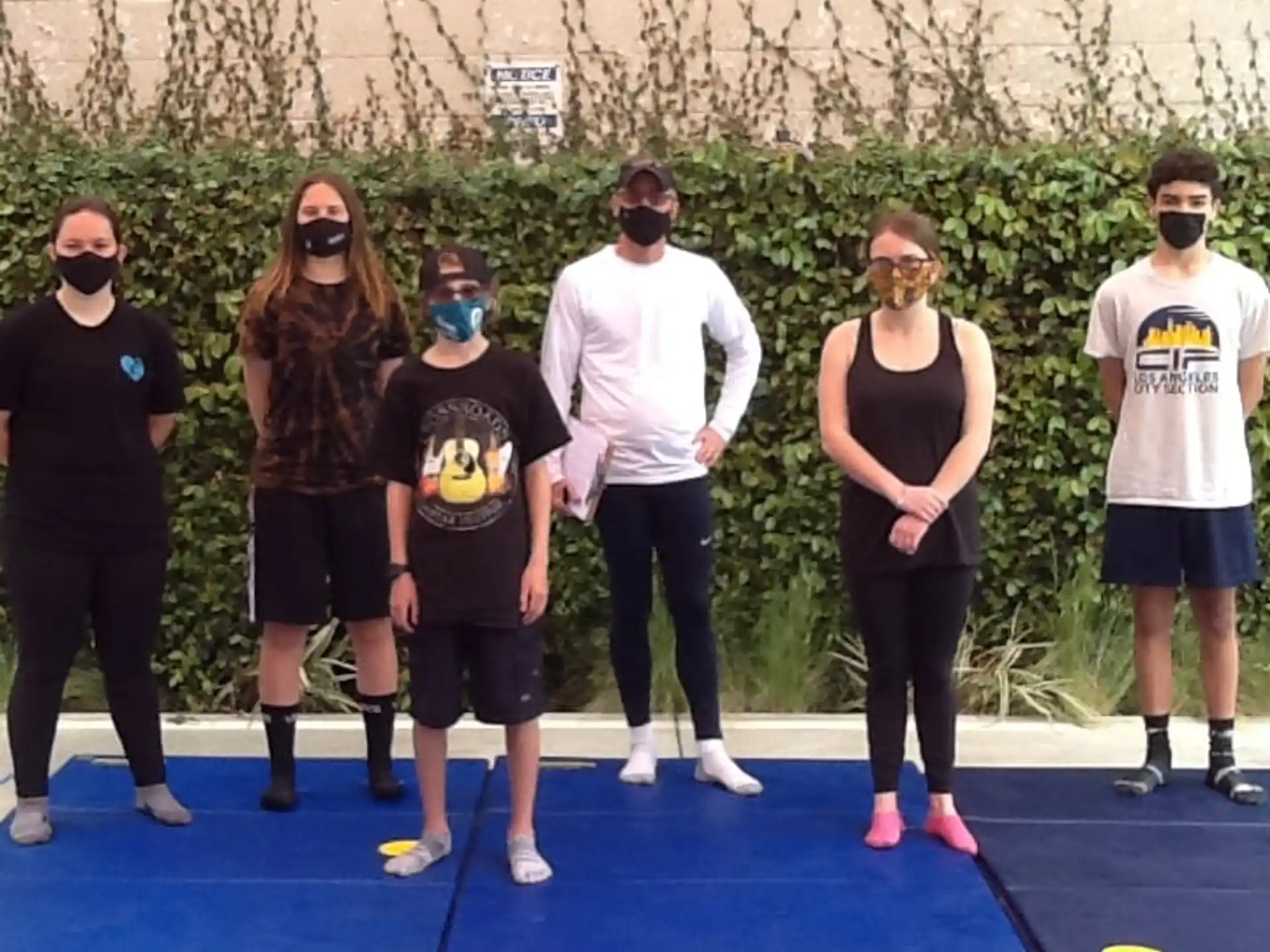 a group of people standing on a blue mat