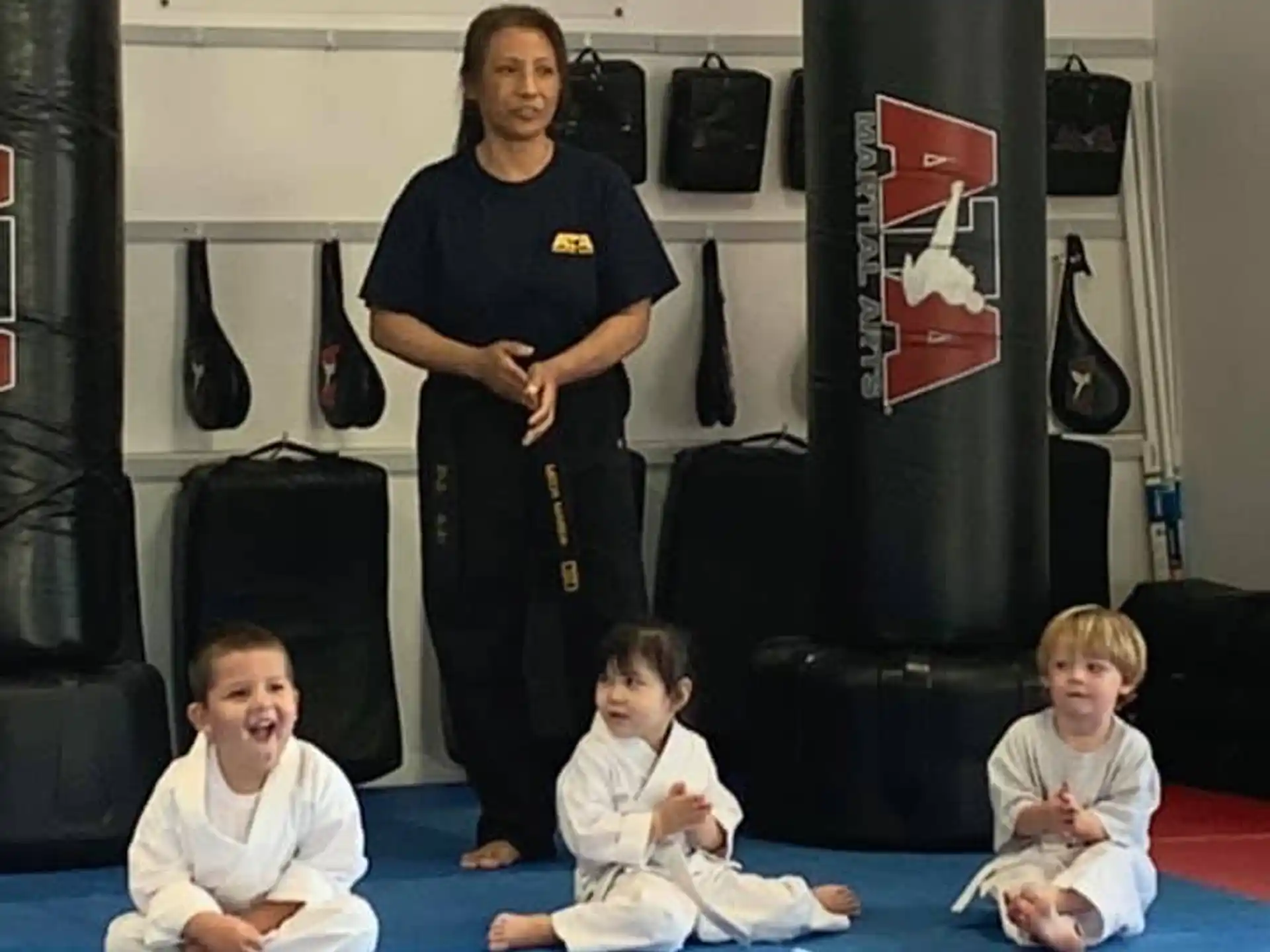 a person standing in front of a group of kids sitting on the floor