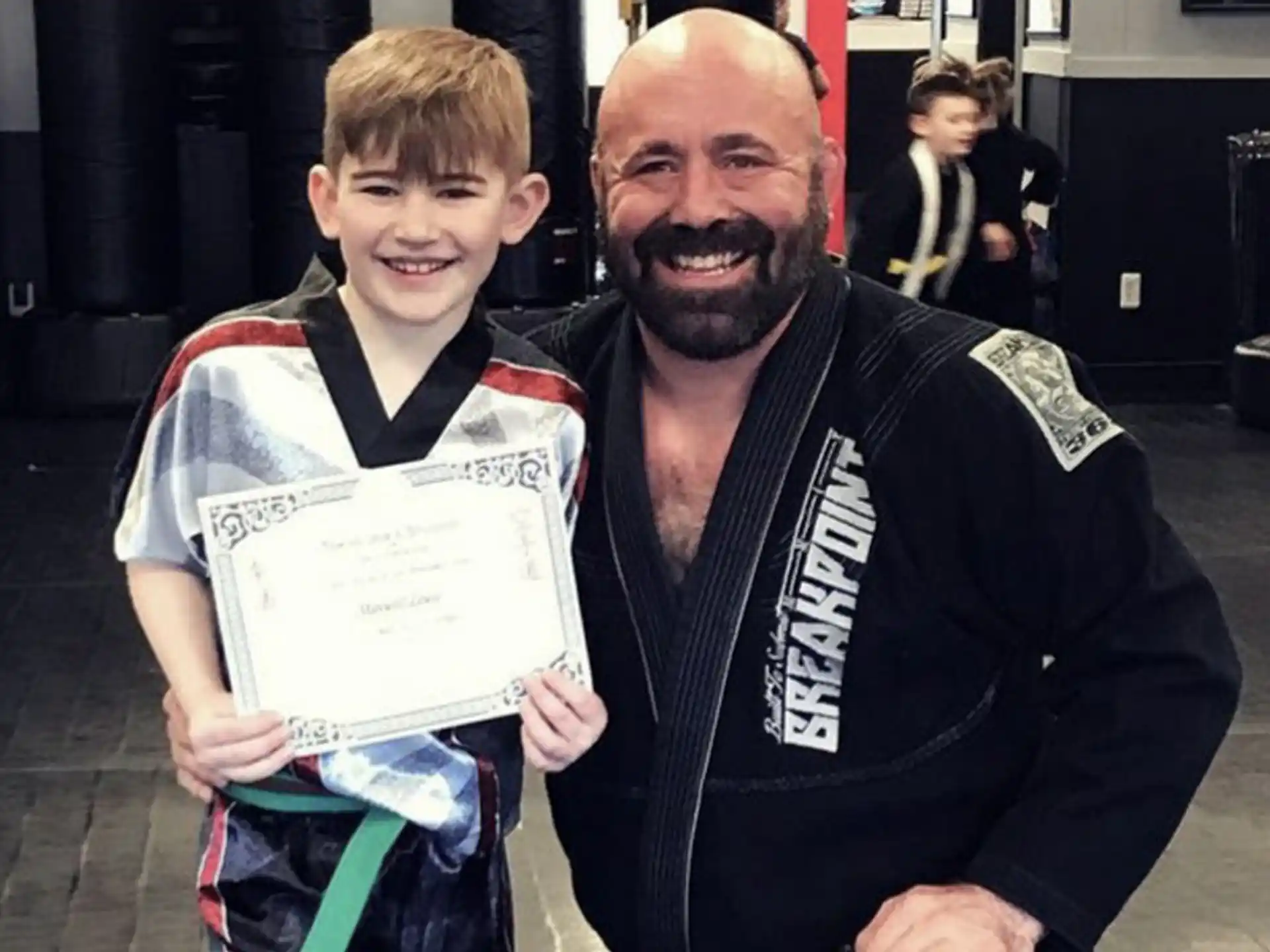 a person and a boy holding a certificate