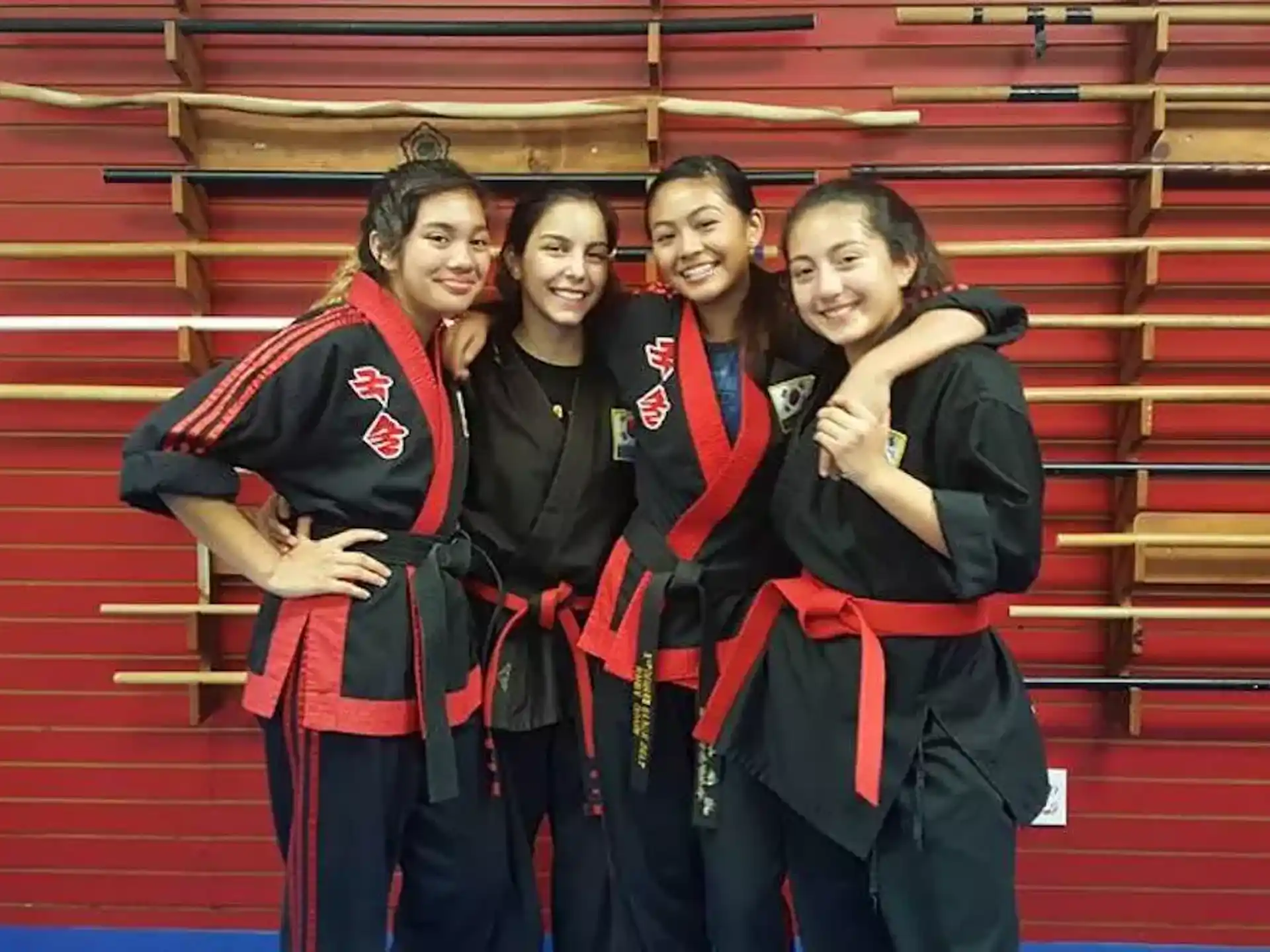 a group of women in black and red graduation gowns