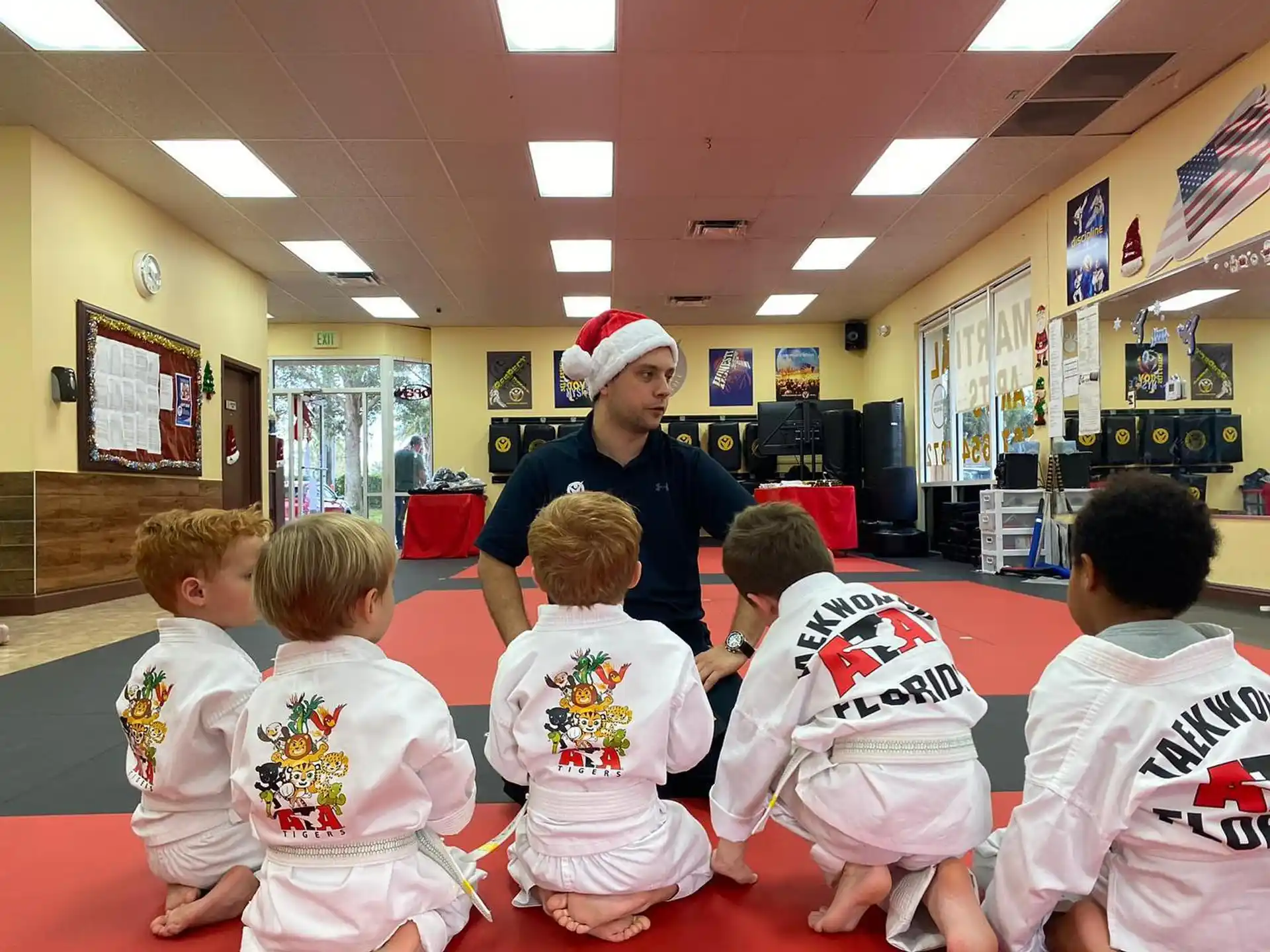 a man standing in front of a group of children in a classroom