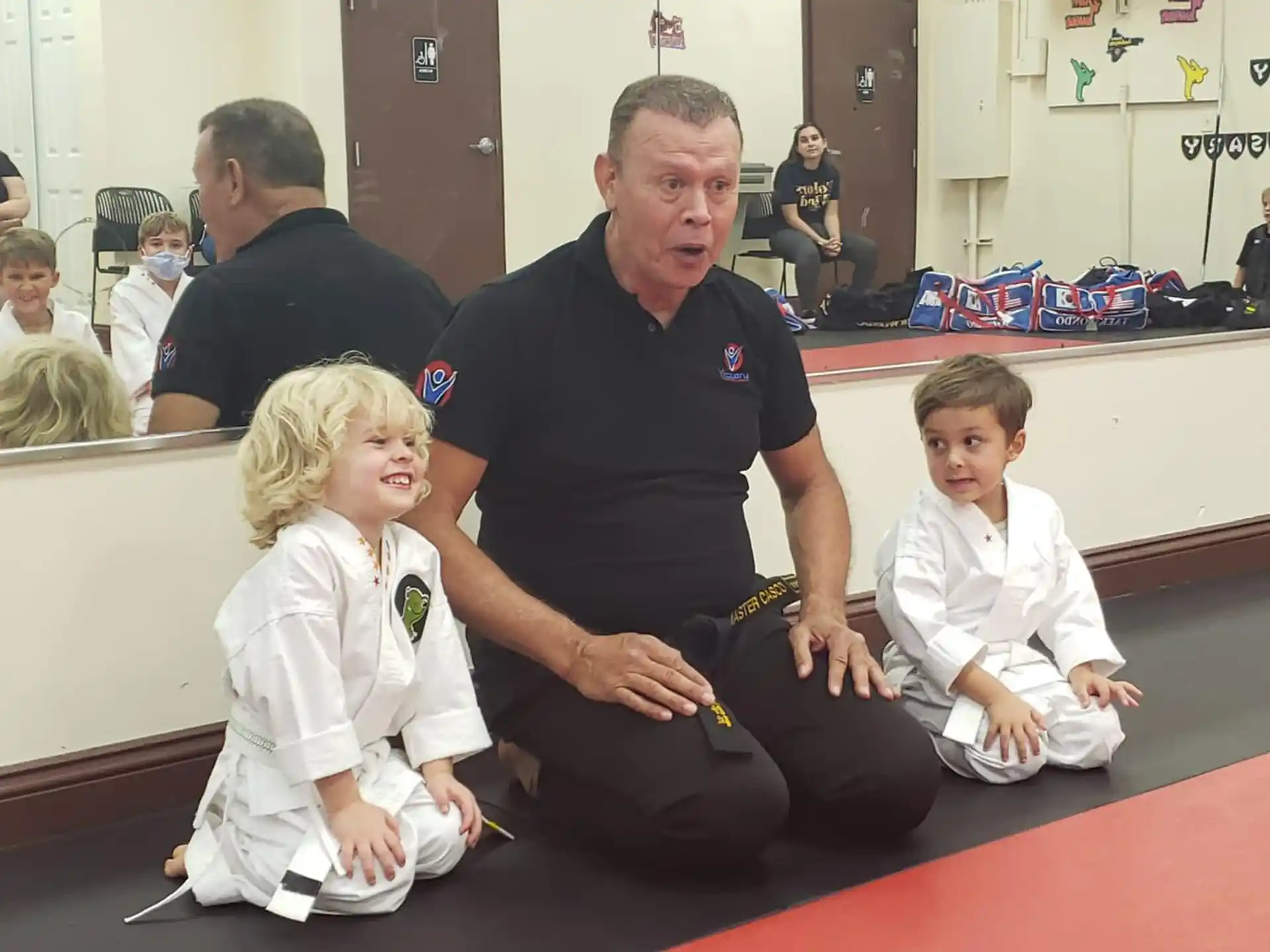 a person kneeling next to two children