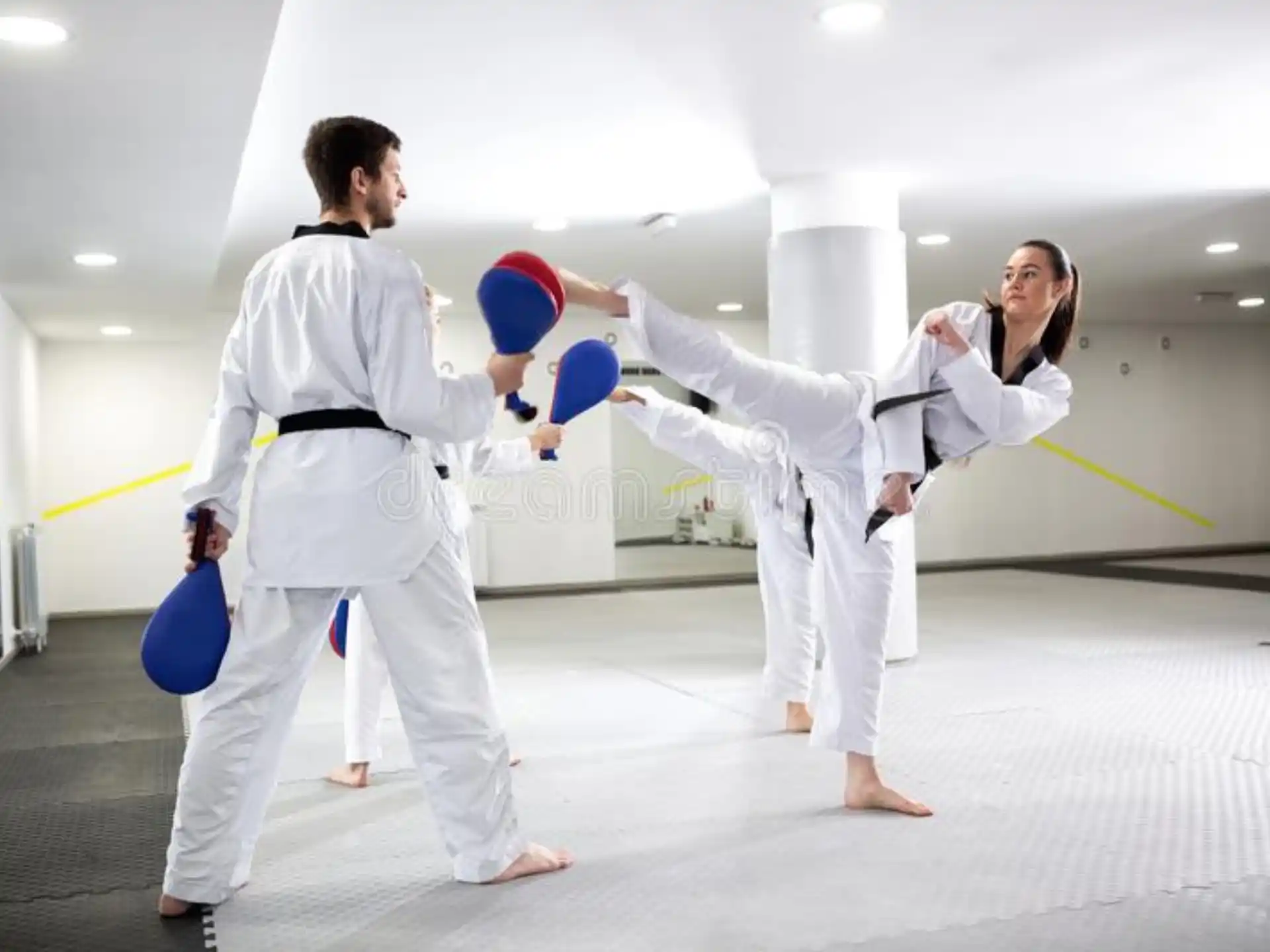 a man and woman in white karate uniforms with blue gloves