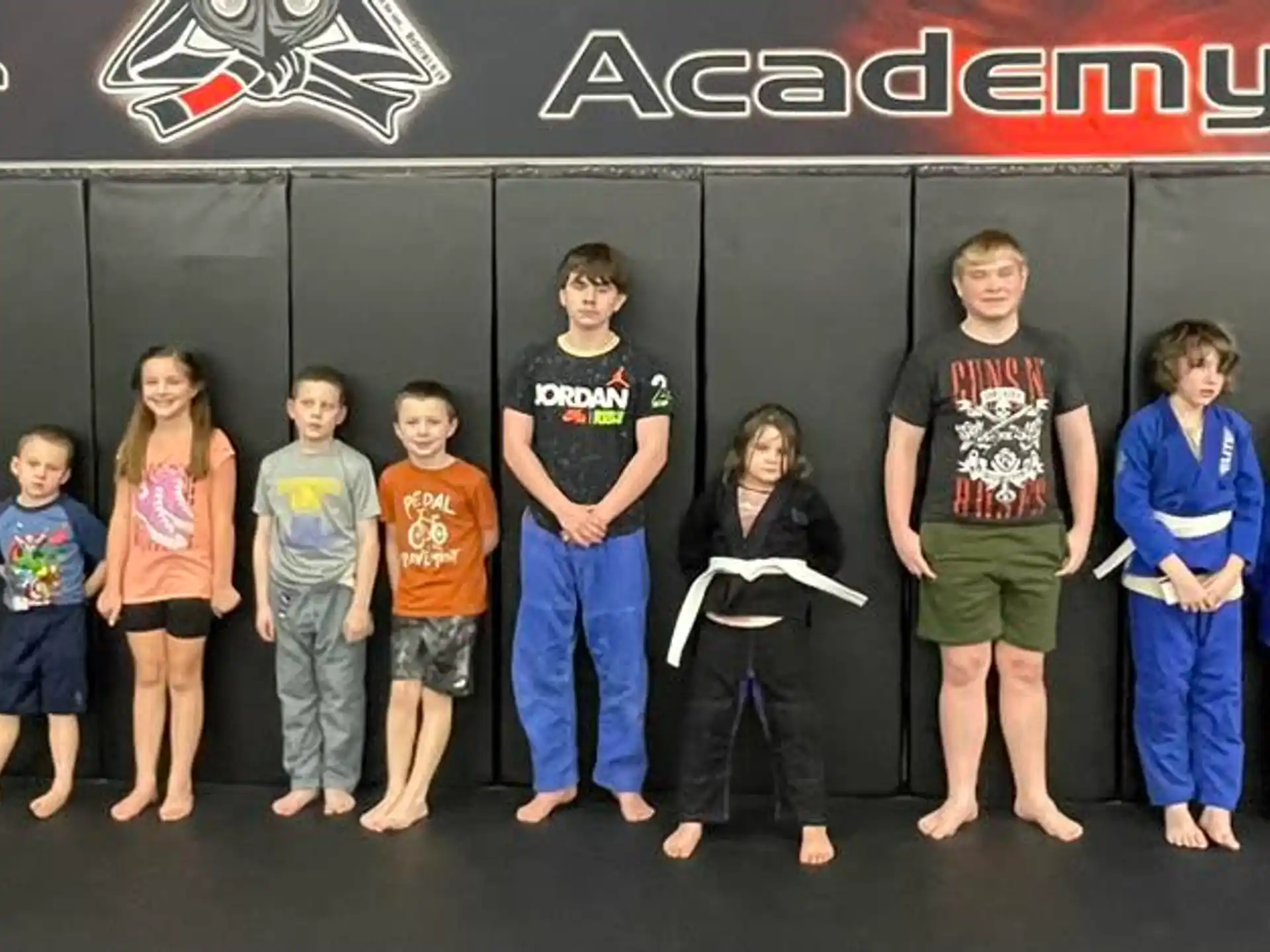a group of people standing in front of a black wall