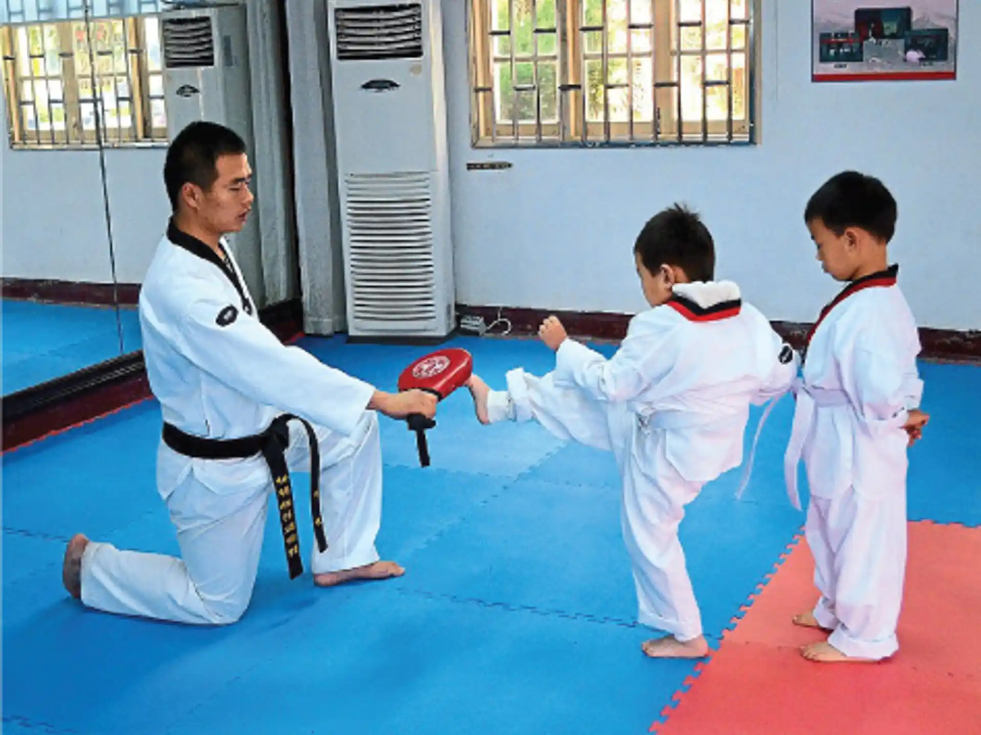 a person and two boys in karate uniforms