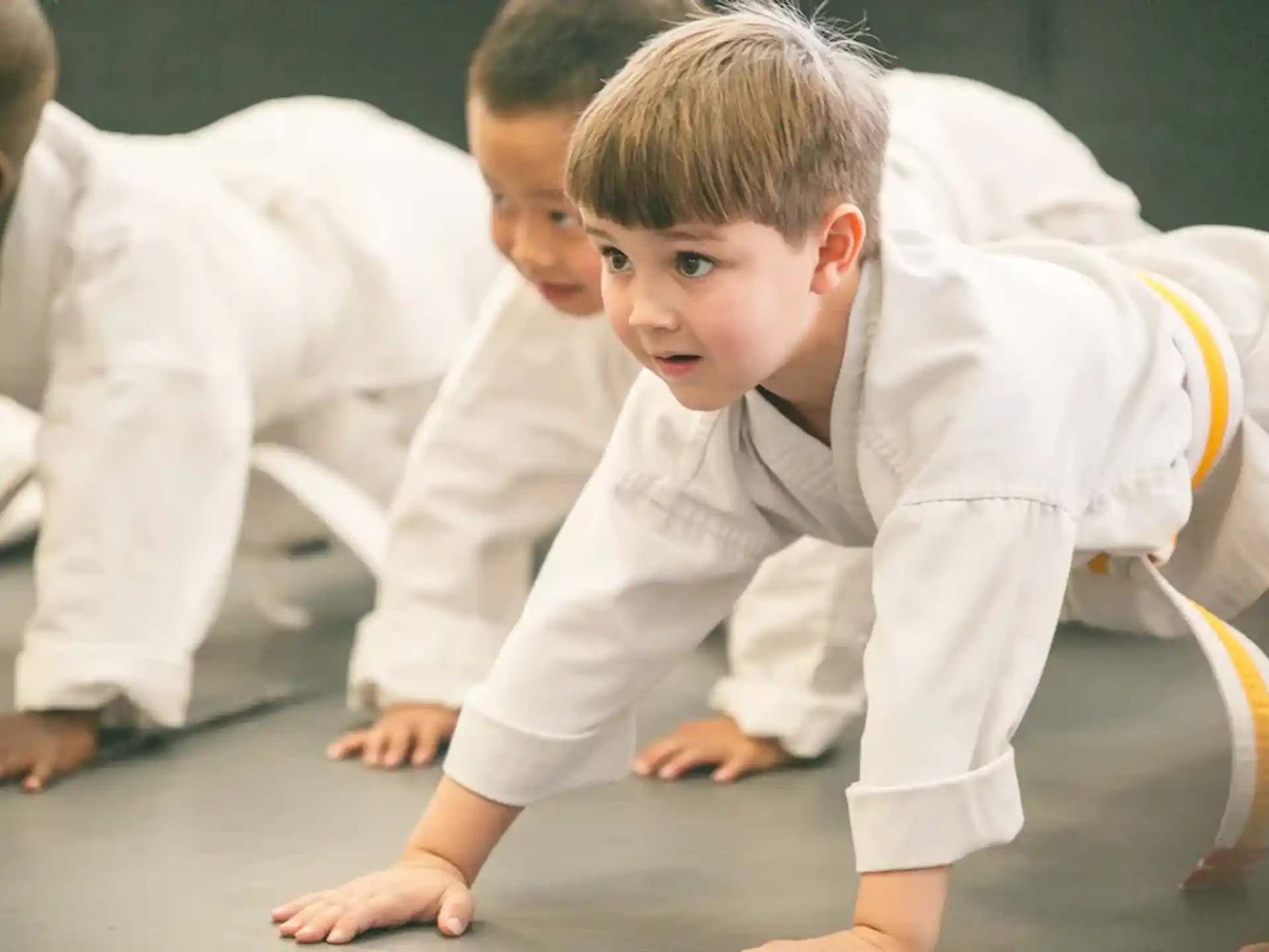 a young boy and a young girl in karate uniforms
