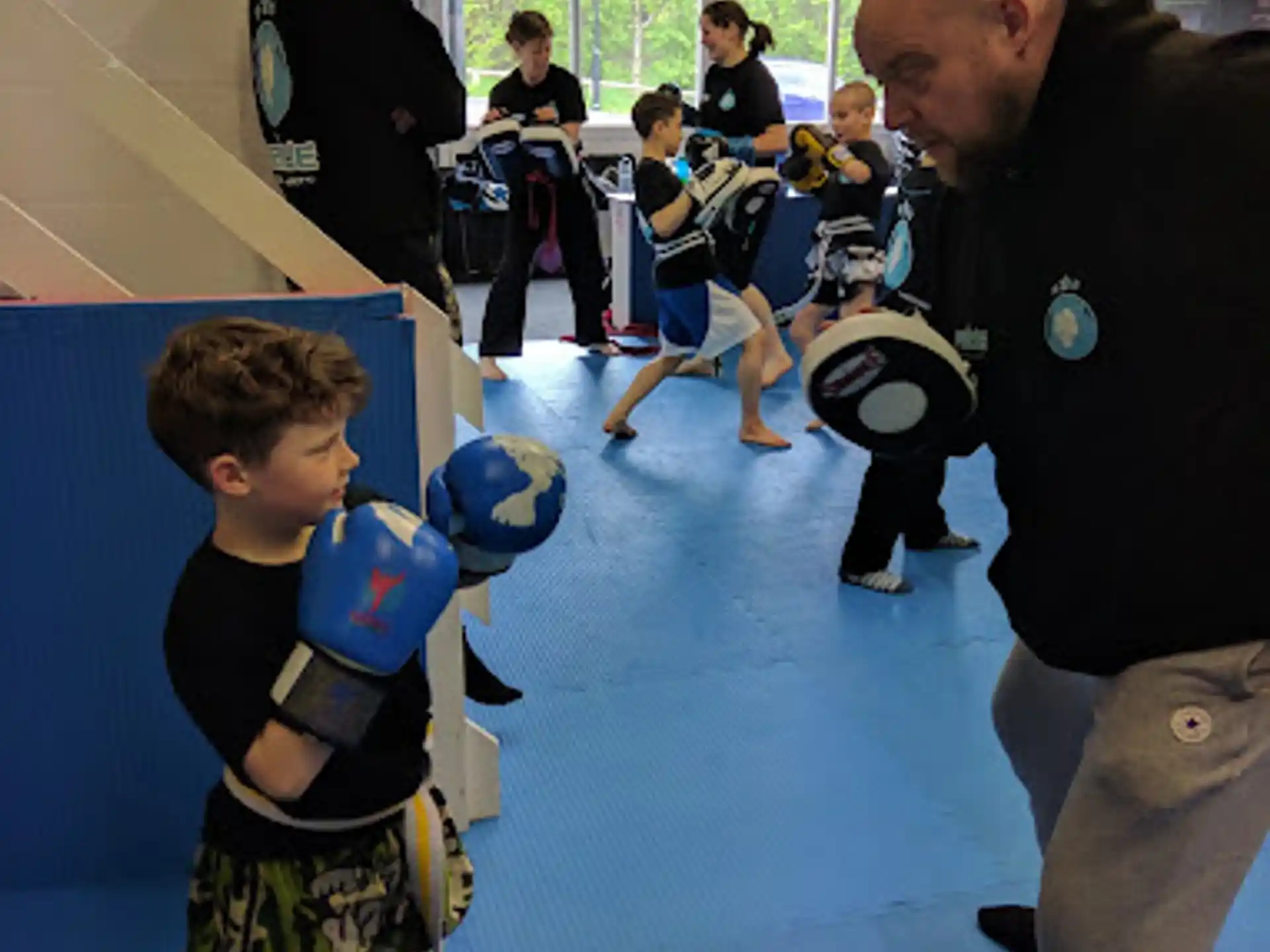 a person and a boy playing with balls in a gym
