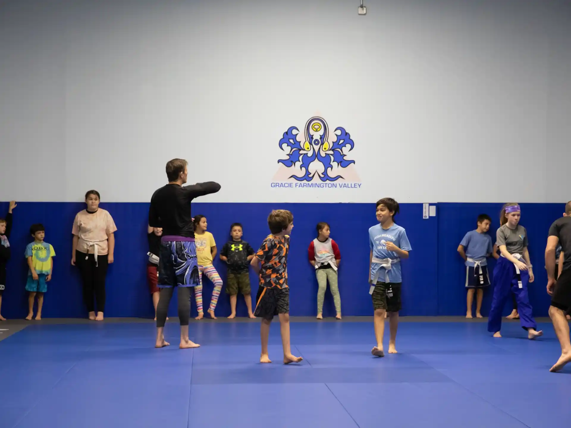 a group of people standing in a room with a blue wall
