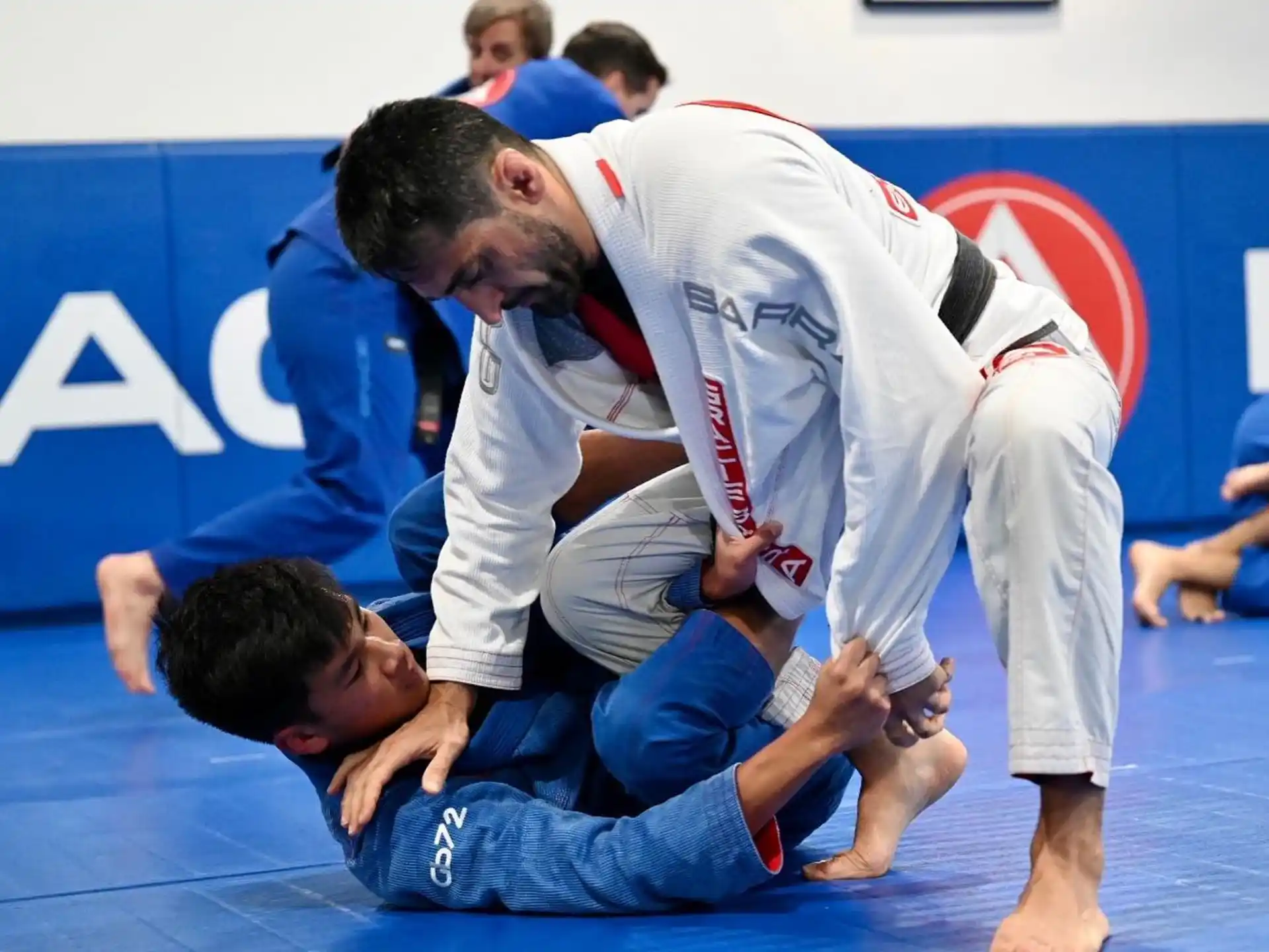 a man in a karate uniform helping a boy who is lying on the ground