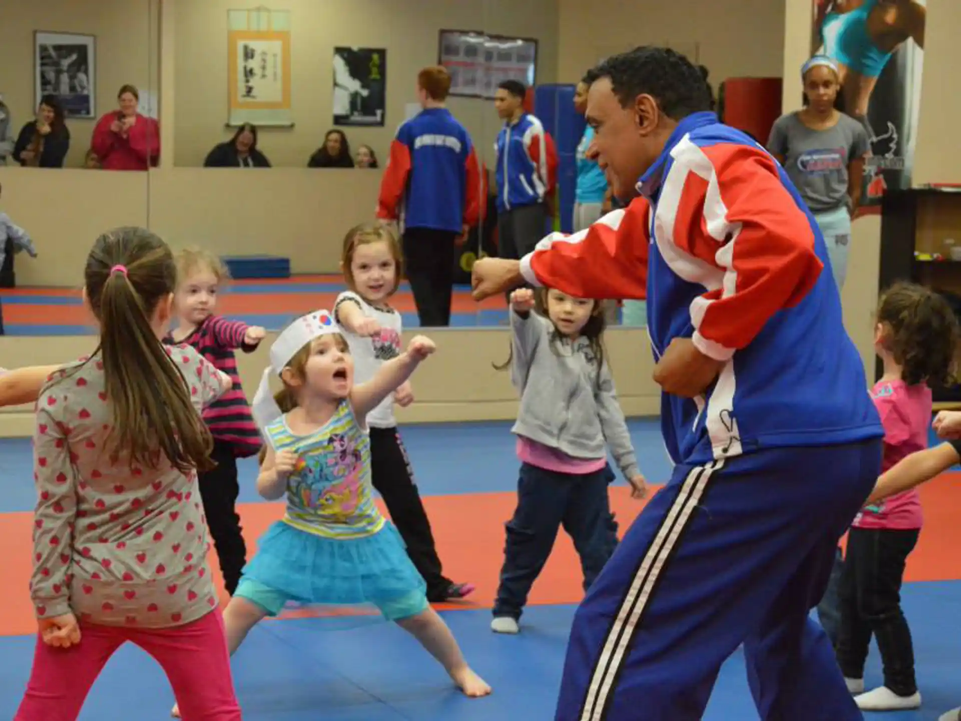 a person and a group of children in a gym