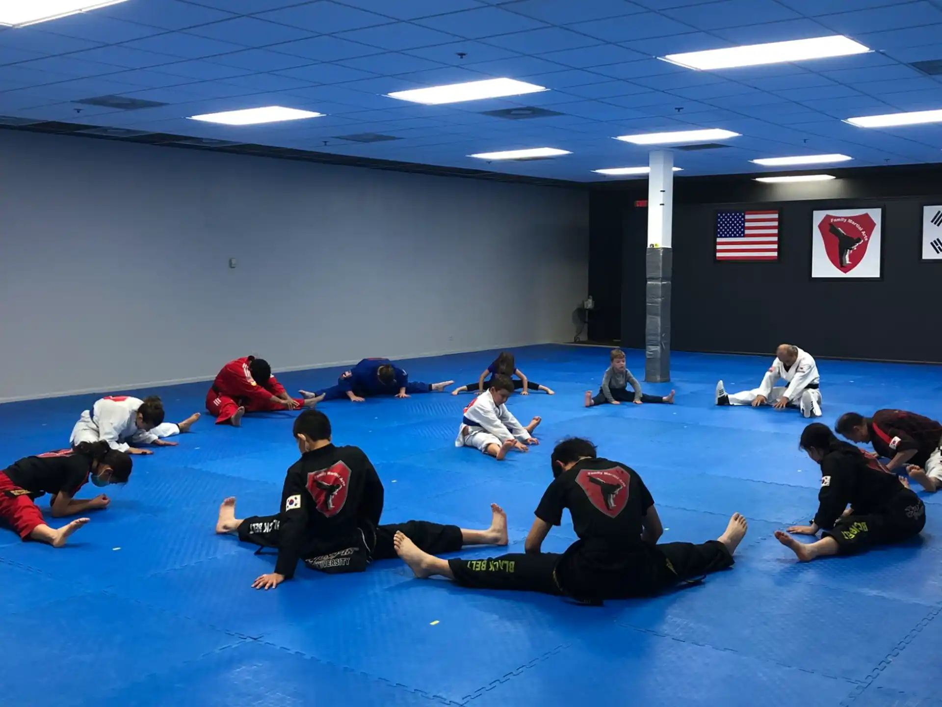 a group of people sitting on a mat in a room