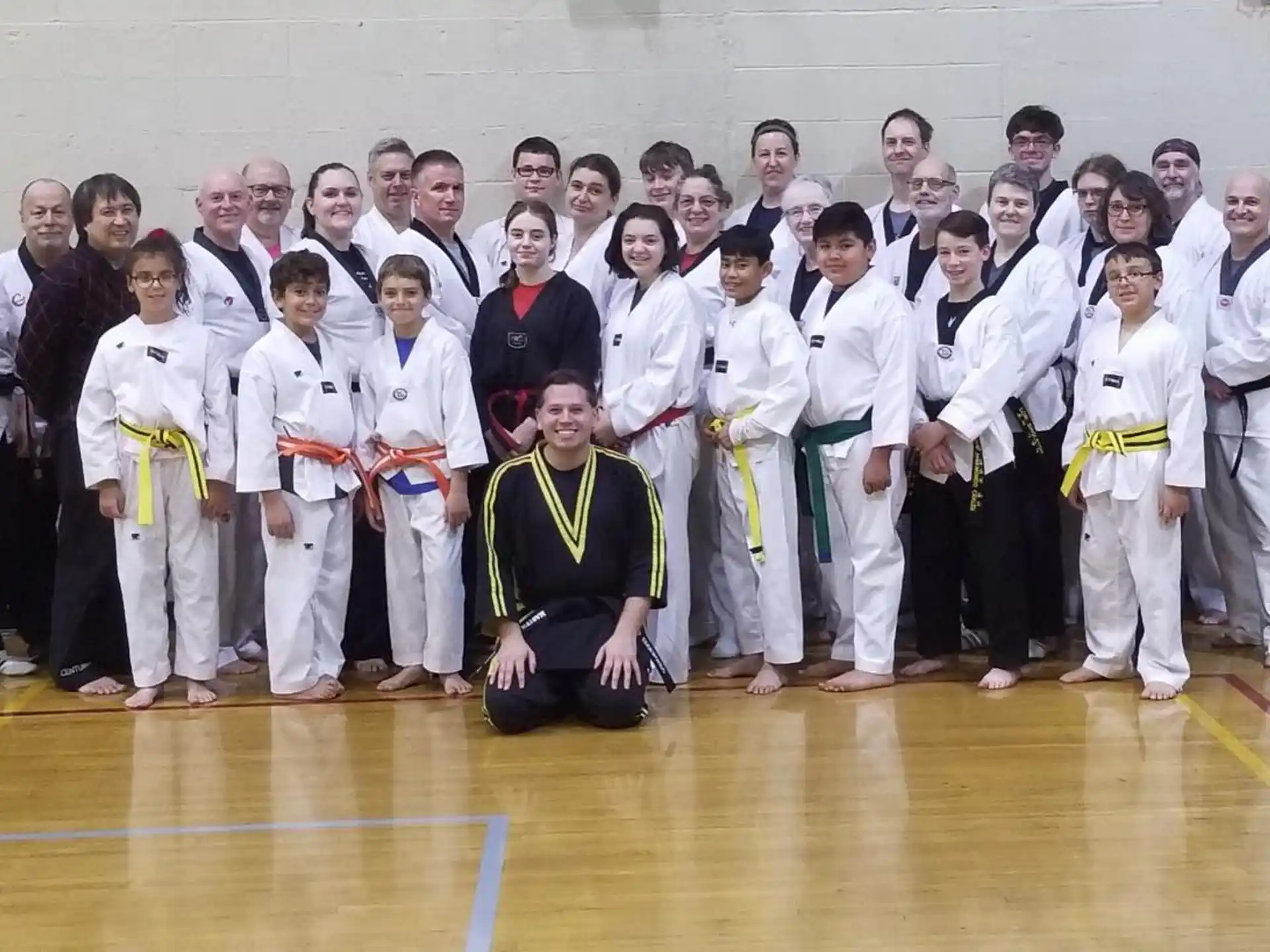 a group of people in white karate uniforms posing for a photo
