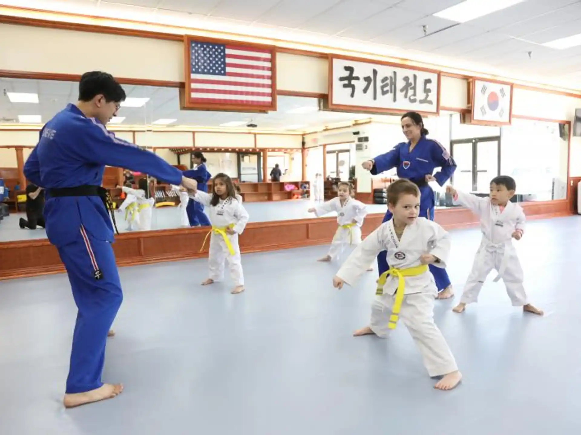 a person and a group of children in karate uniforms