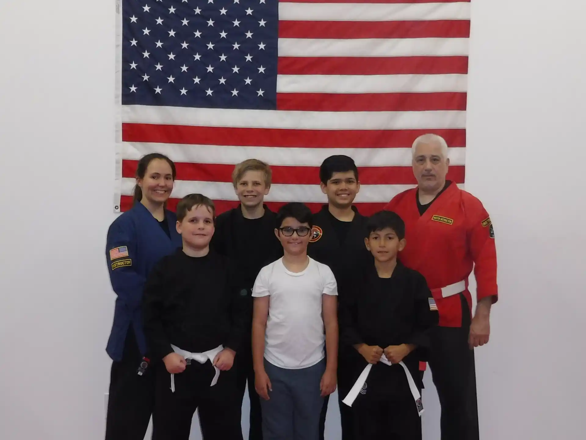 a group of people posing for a photo in front of a flag