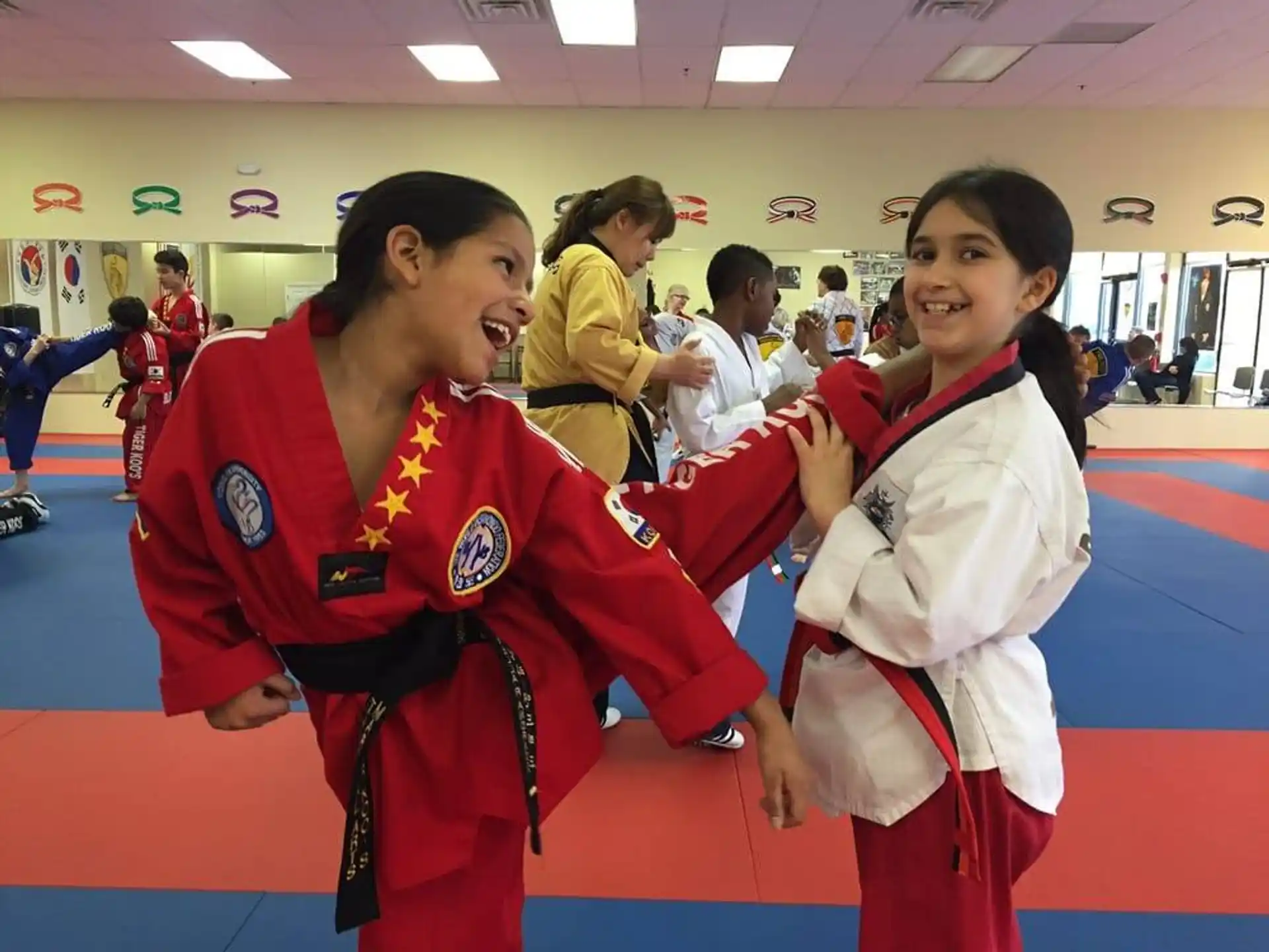 a couple of girls in red karate uniforms
